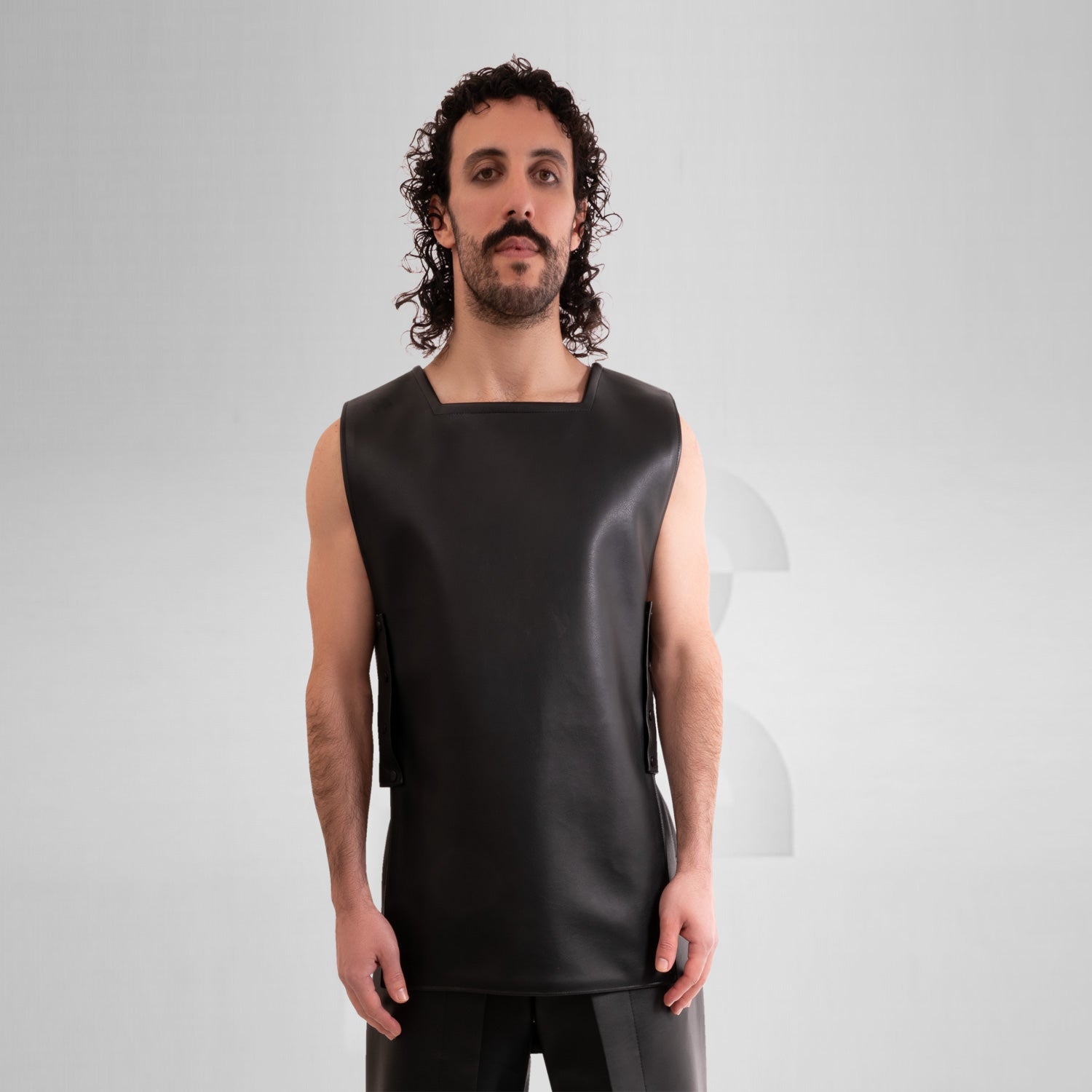 A close-up image of a faux leather vest with an avantgarde geometric design.