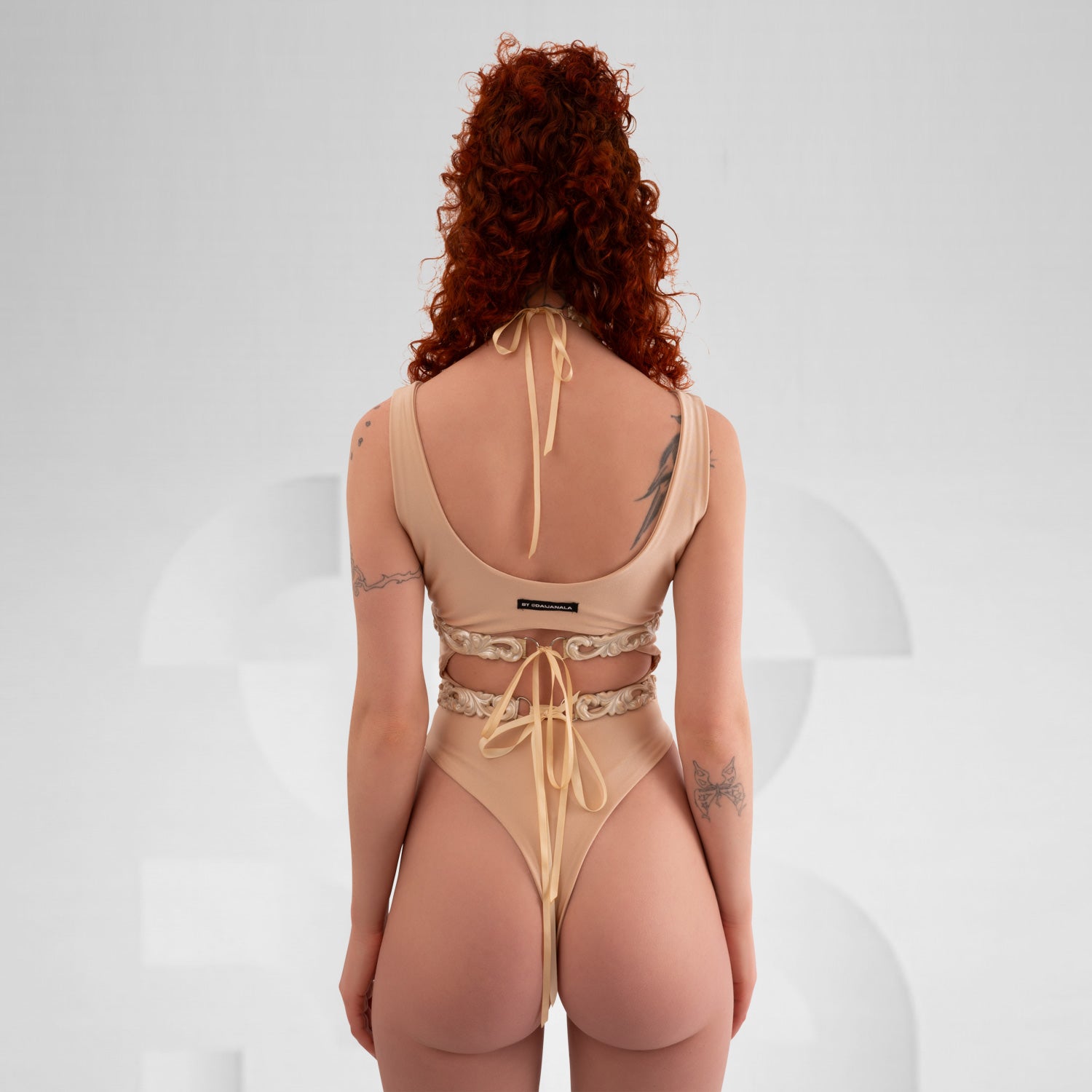 A model elegantly wearing the Baroque 3D Latex Corset in Pearl White, showcasing its intricate design against a light grey background. The corset highlights the model’s silhouette, embodying sophistication and baroque elegance.