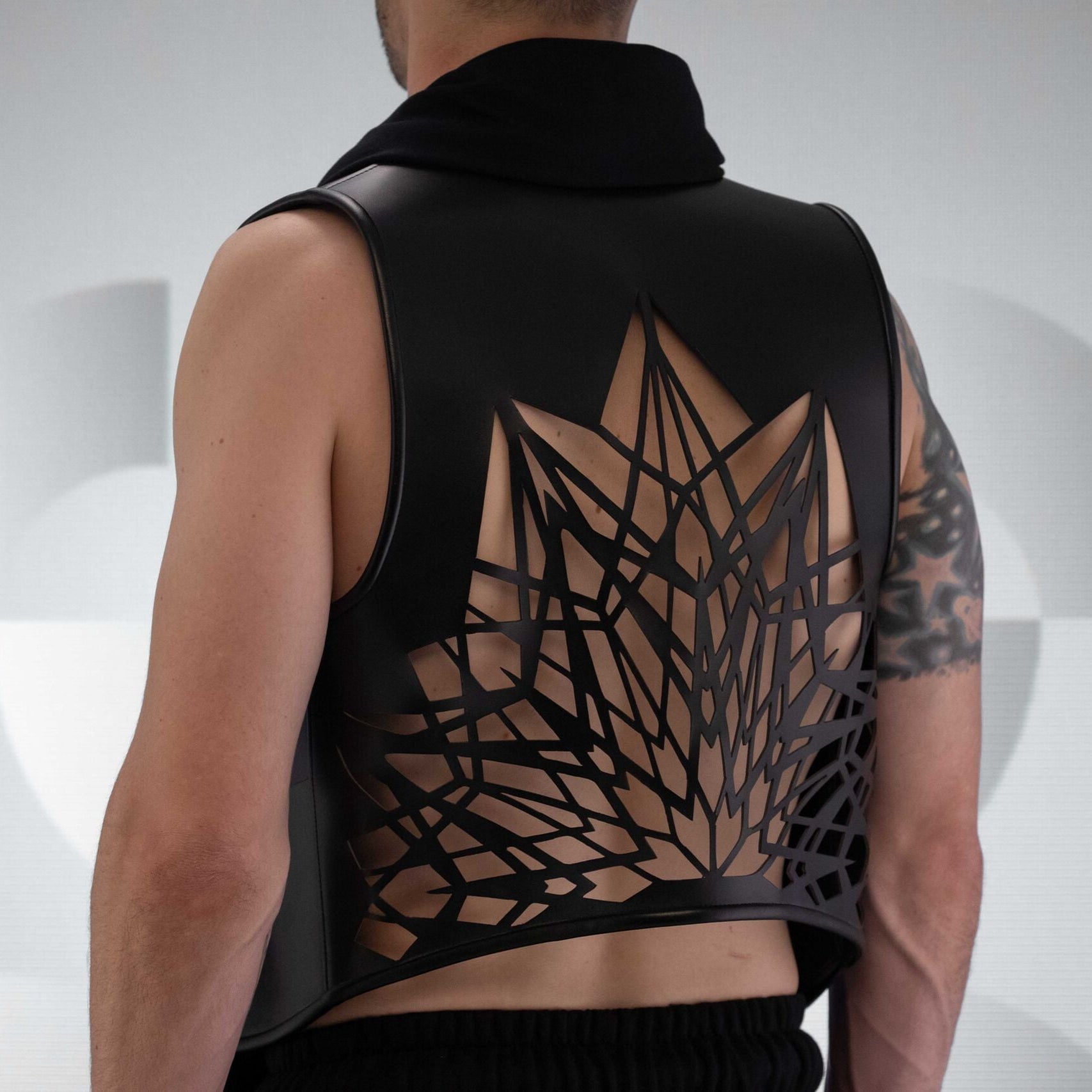 A black Cardigan, with Laser-Cut Geometric Back Design made out of Intricate vegan leather.