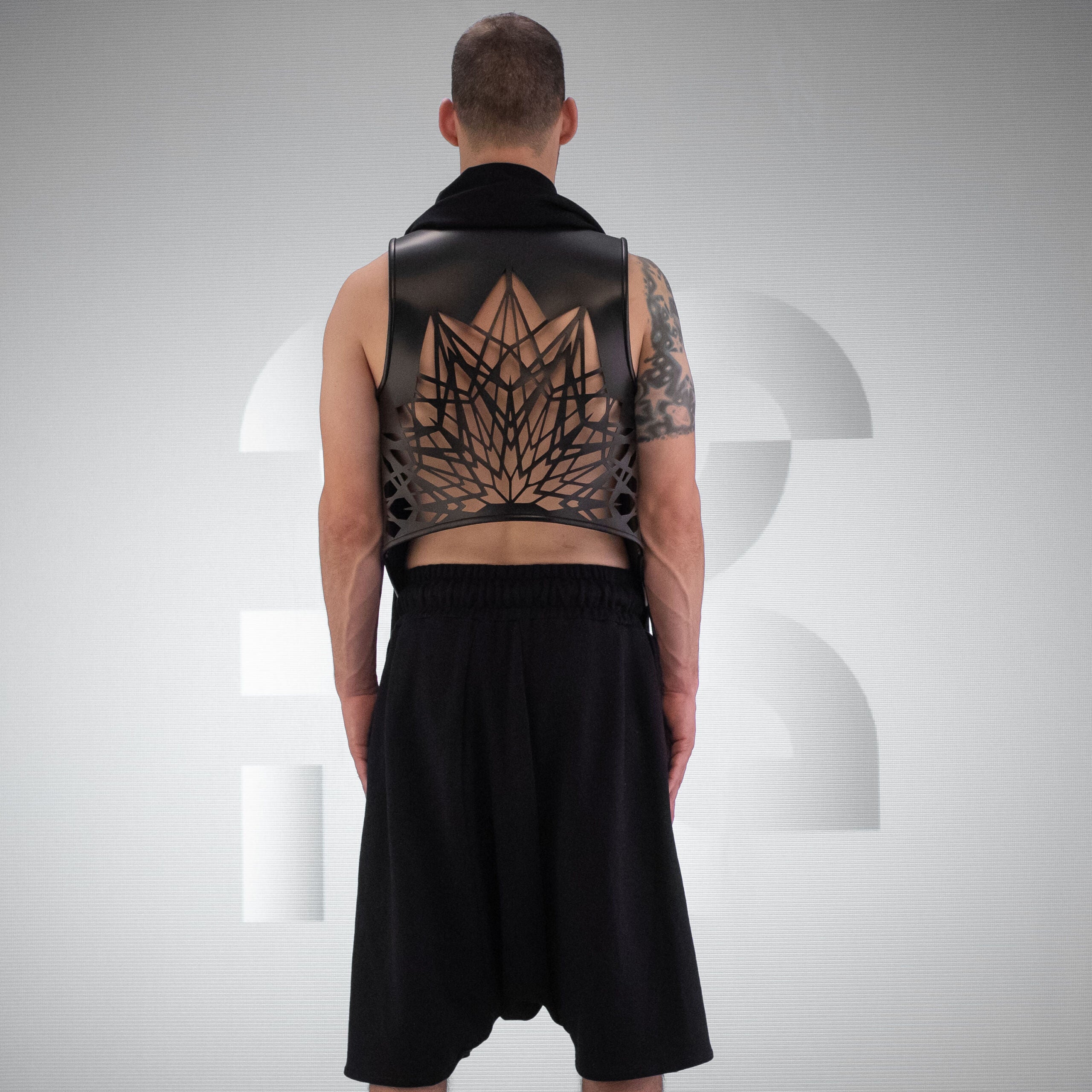 A black Cardigan, with Laser-Cut Geometric Back Design made out of Intricate vegan leather.