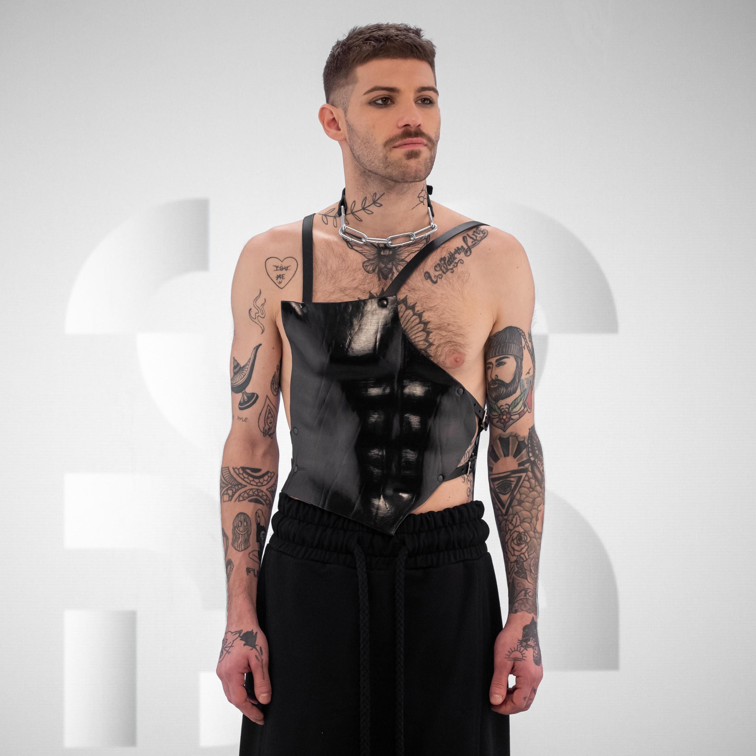 Anatomical leather harness with sculpted chest plate and adjustable straps, serving avant-garde looks.