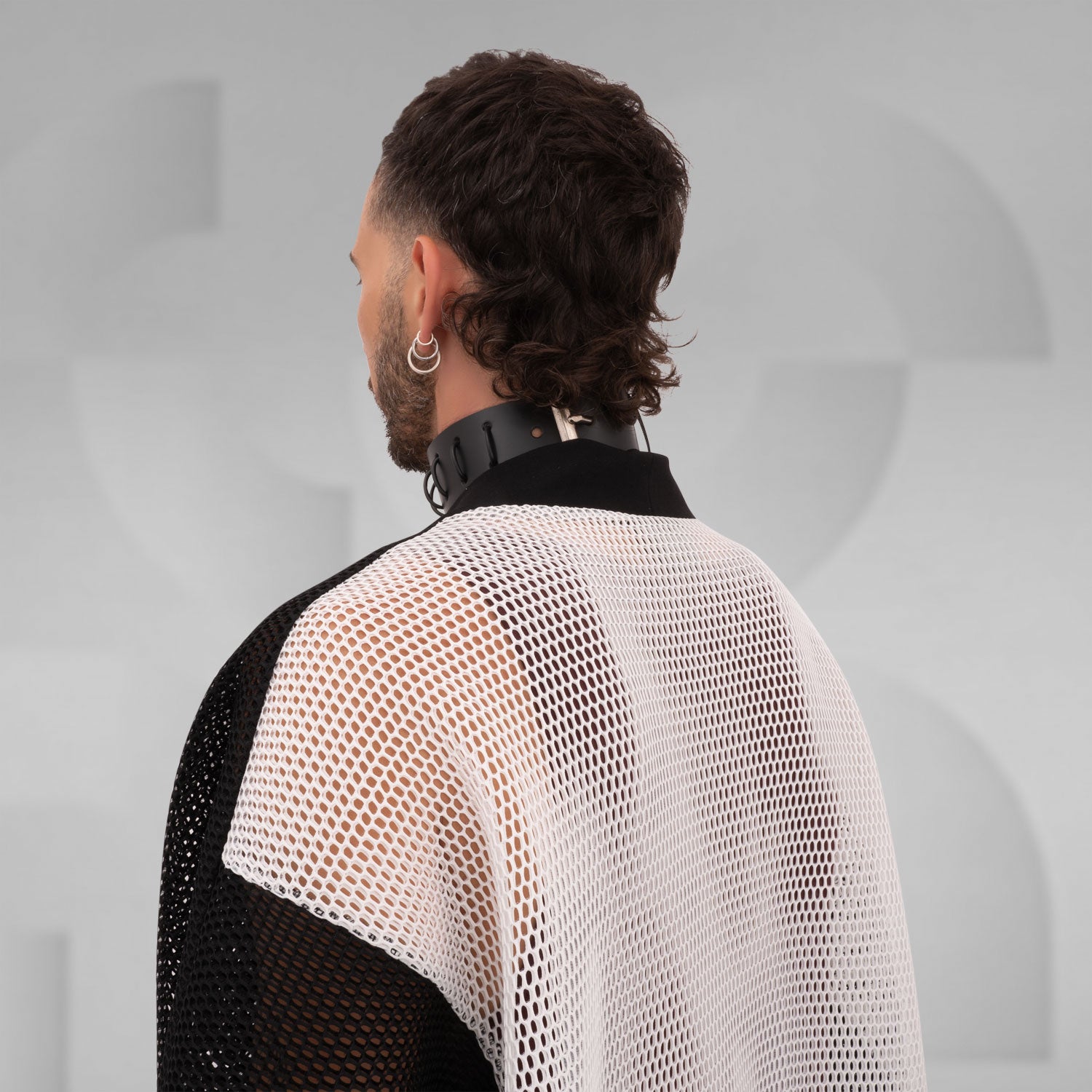 Black and white mesh cardigan with wide sleeves, designed for an edgy, modern look, reflecting the Berlin club scene aesthetic.