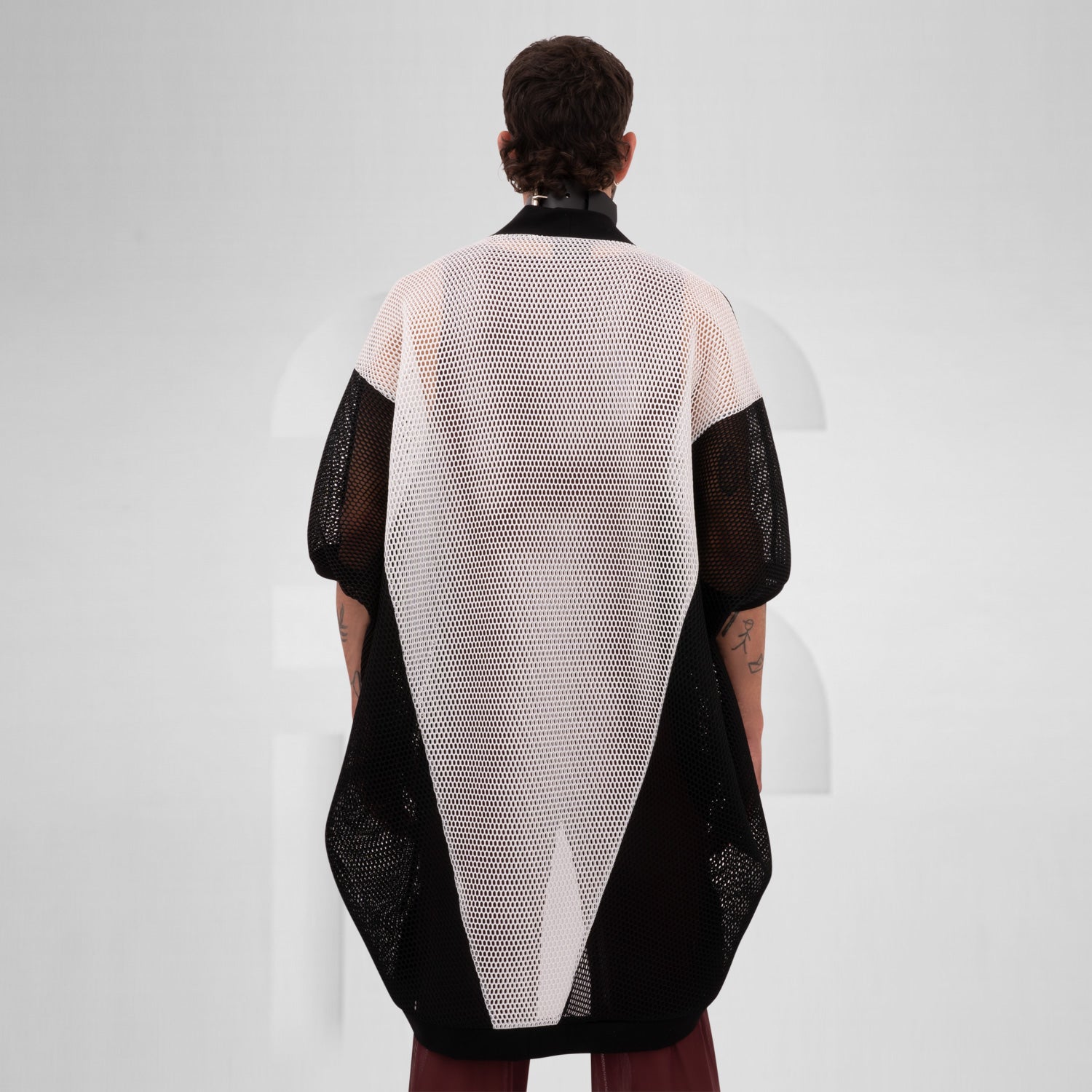 Black and white mesh cardigan with wide sleeves, designed for an edgy, modern look, reflecting the Berlin club scene aesthetic.