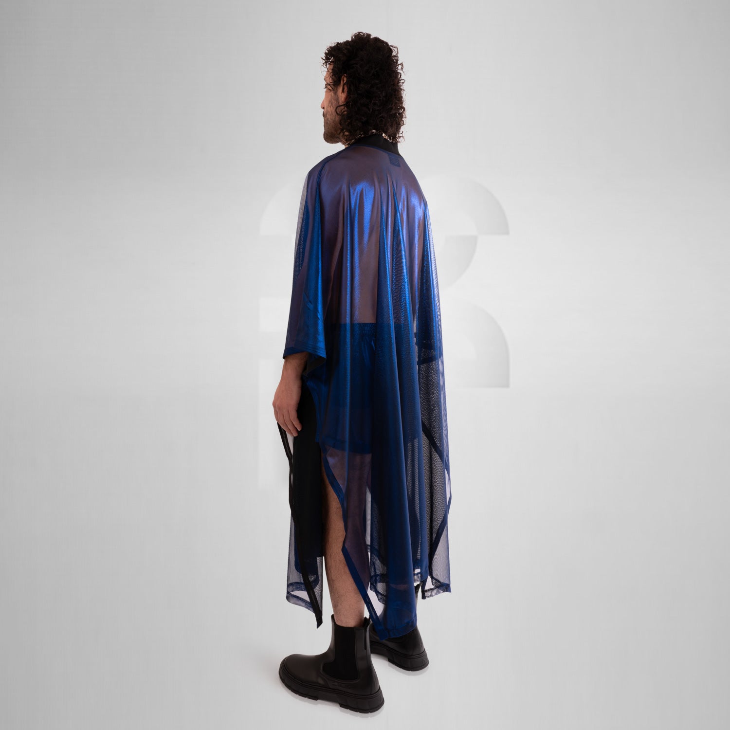 A striking long poncho in red, blue, and silver with a shiny disco festival vibe.