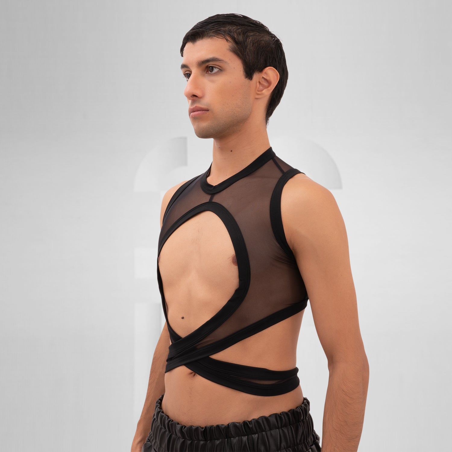 Introducing the Bound Gender-Neutral Mesh Top from Berlin designer Nur Hektor. This avant-garde piece combines sheer mesh with a daring wraparound design, making it perfect for festivals and clubwear. The striking cut-out detail offers a bold yet stylish silhouette, allowing for expressive individuality and a unique fashion statement.