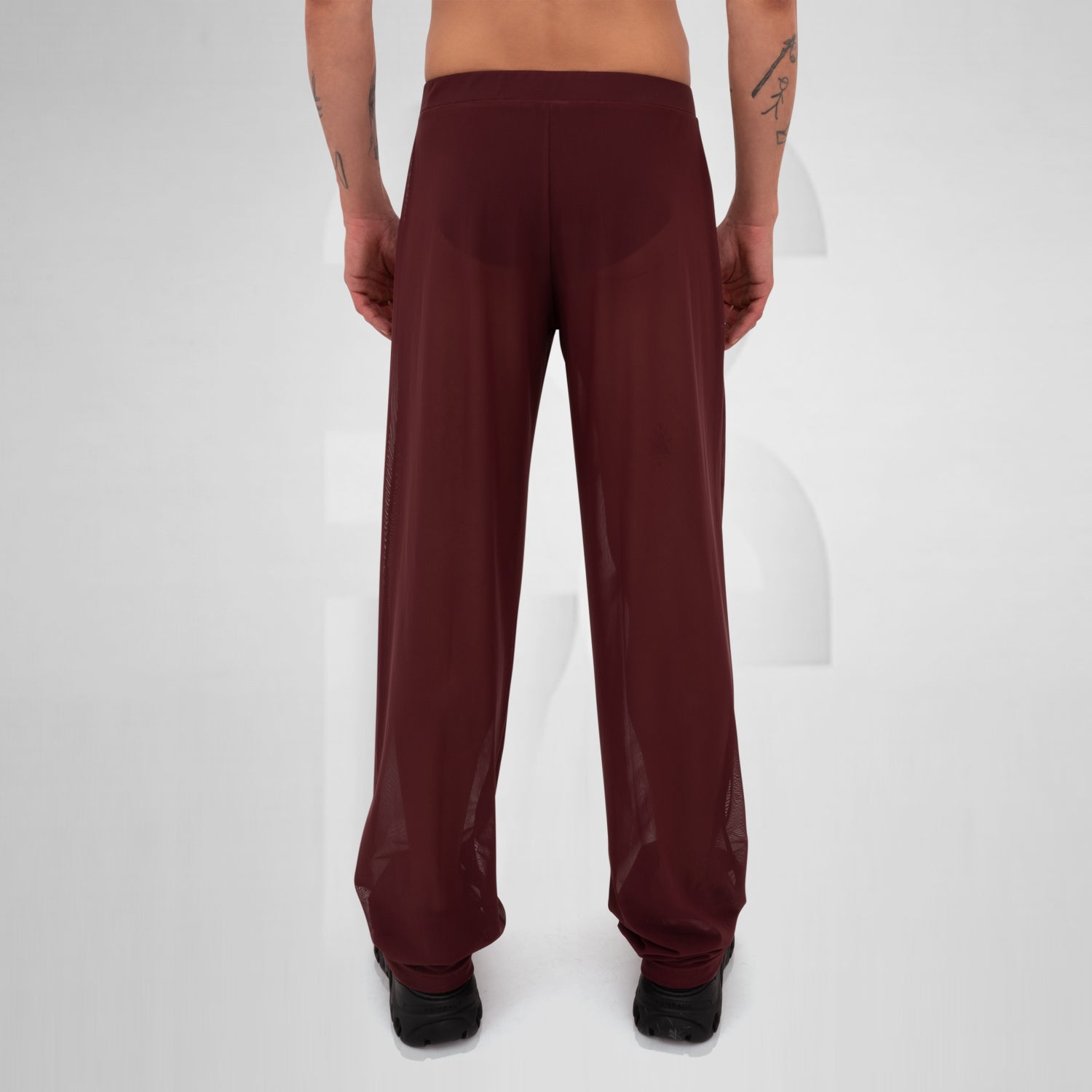 Gender-neutral red mesh pants with a relaxed fit, designed for the Berlin club scene and modern clubwear fashion.