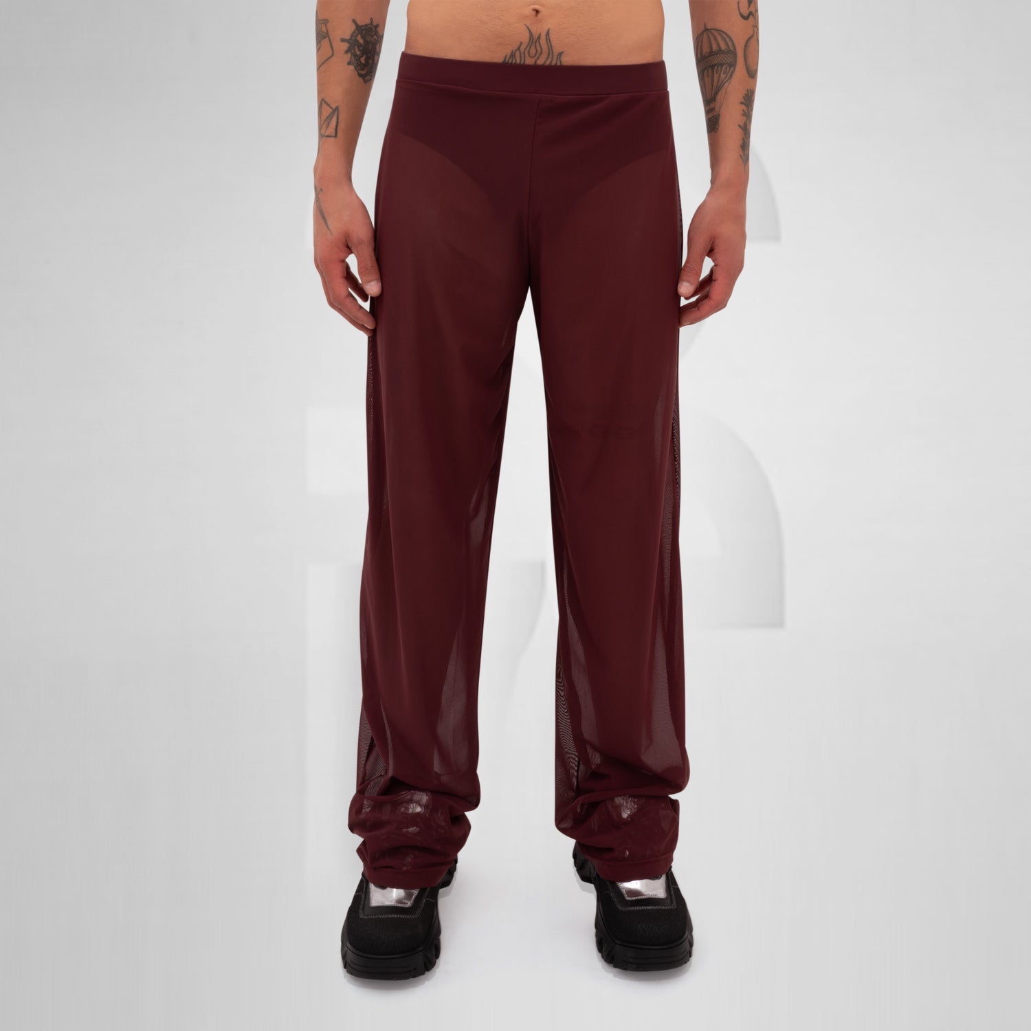 Gender-neutral red mesh pants with a relaxed fit, designed for the Berlin club scene and modern clubwear fashion.