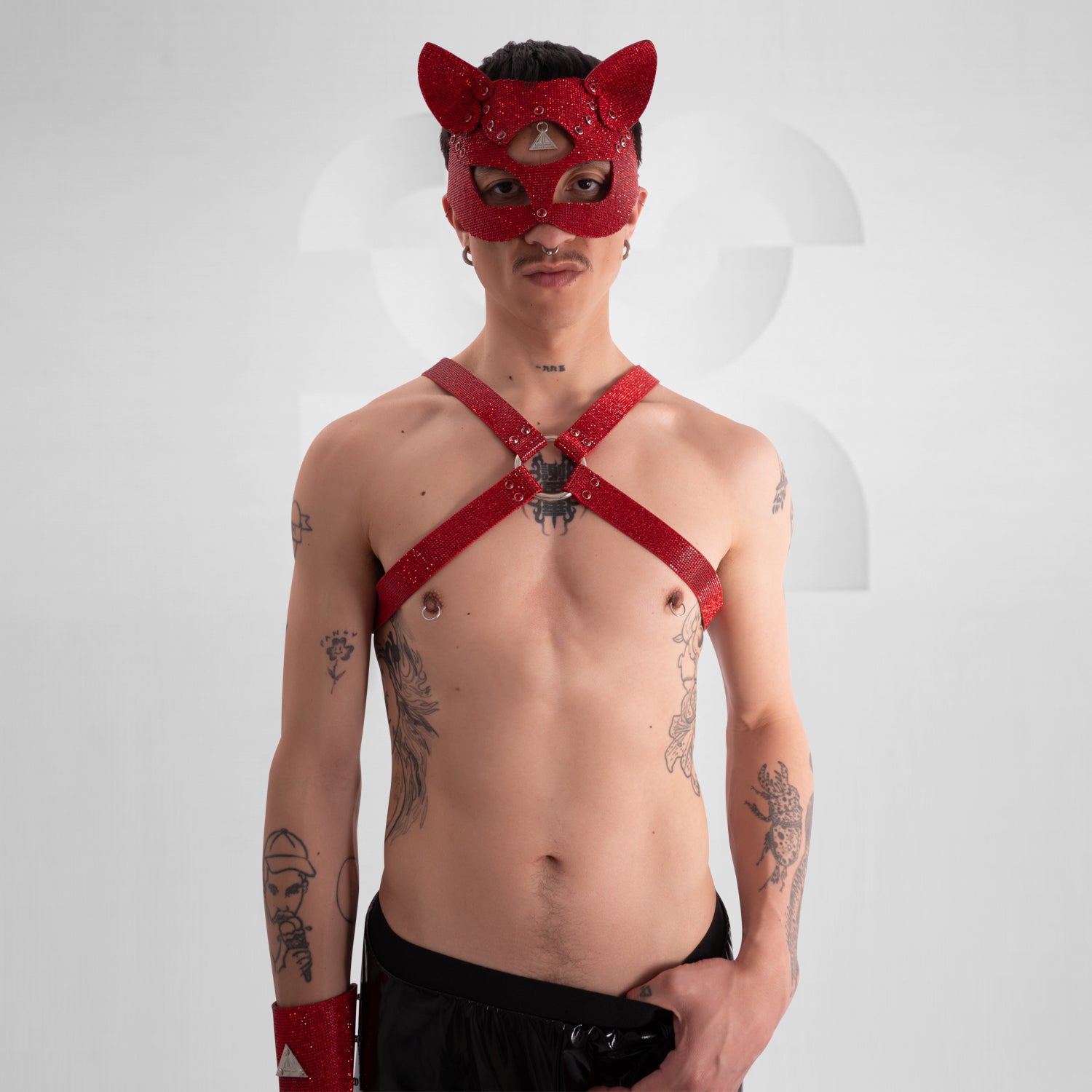 Person wearing a red harness and mask on a white background