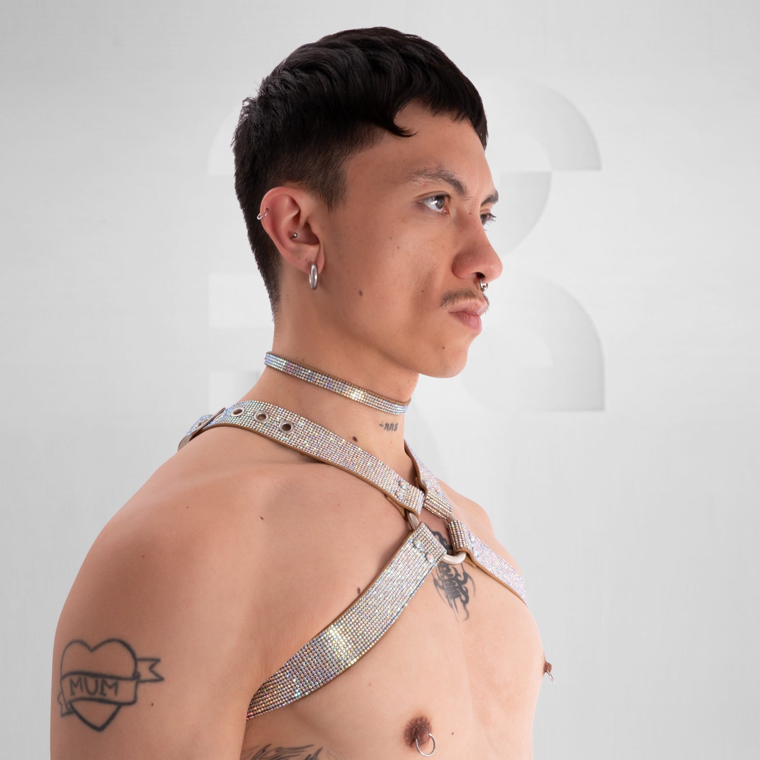Person wearing a sparkling silver harness against a plain background