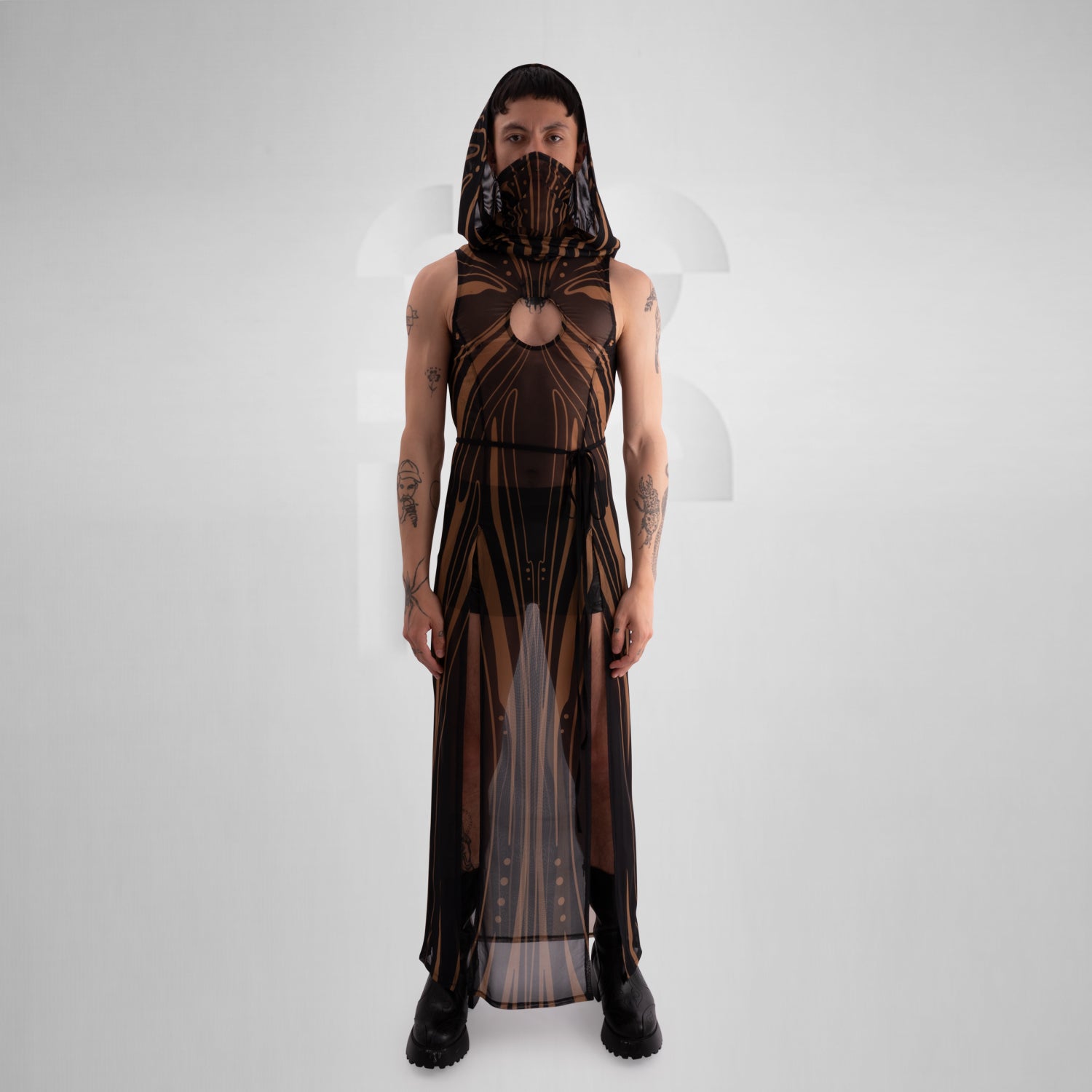 The image showcases a striking, futuristic sheer dress with intricate gold detailing and a matching hood, creating a bold and avant-garde look. 