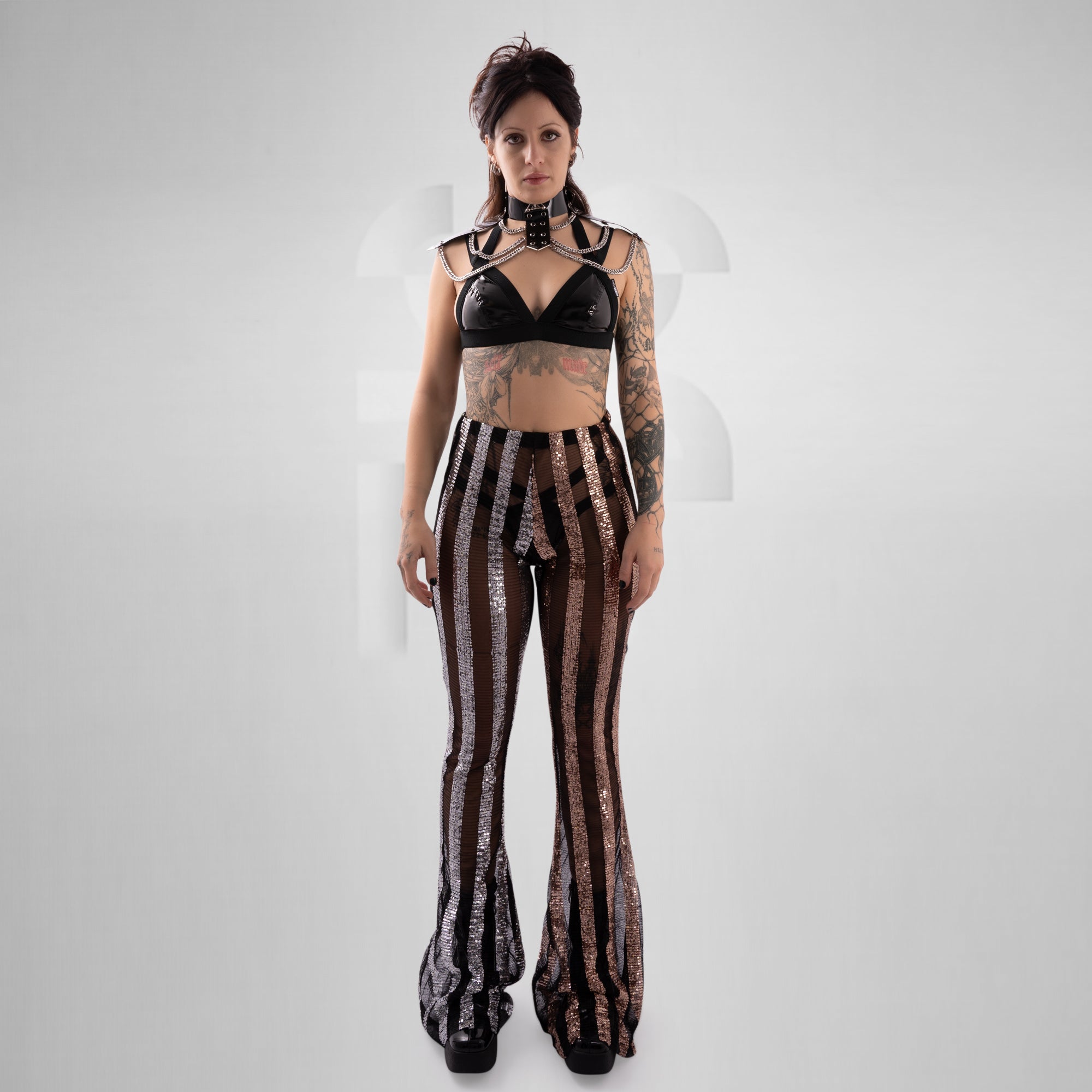 Woman wearing a black top and patterned pants on a white background