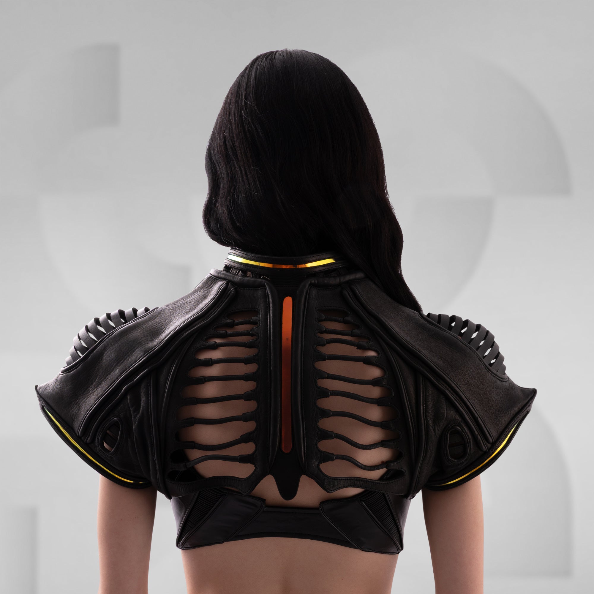 Black leather outfit with cut-out design on a plain background