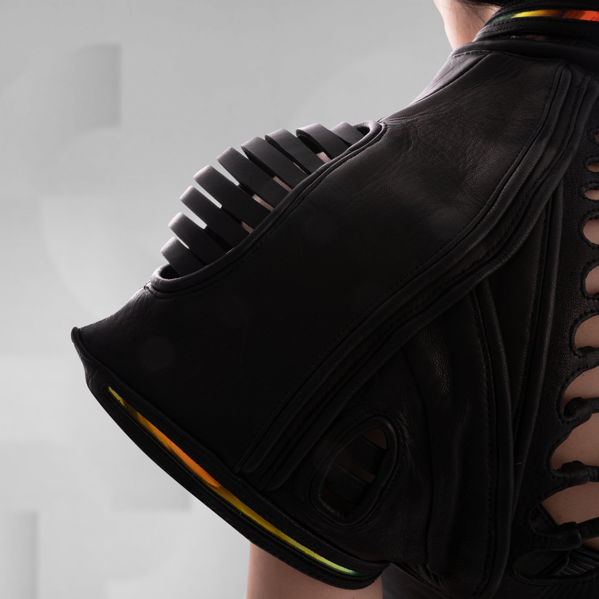 Black jacket with unique shoulder design on a plain background