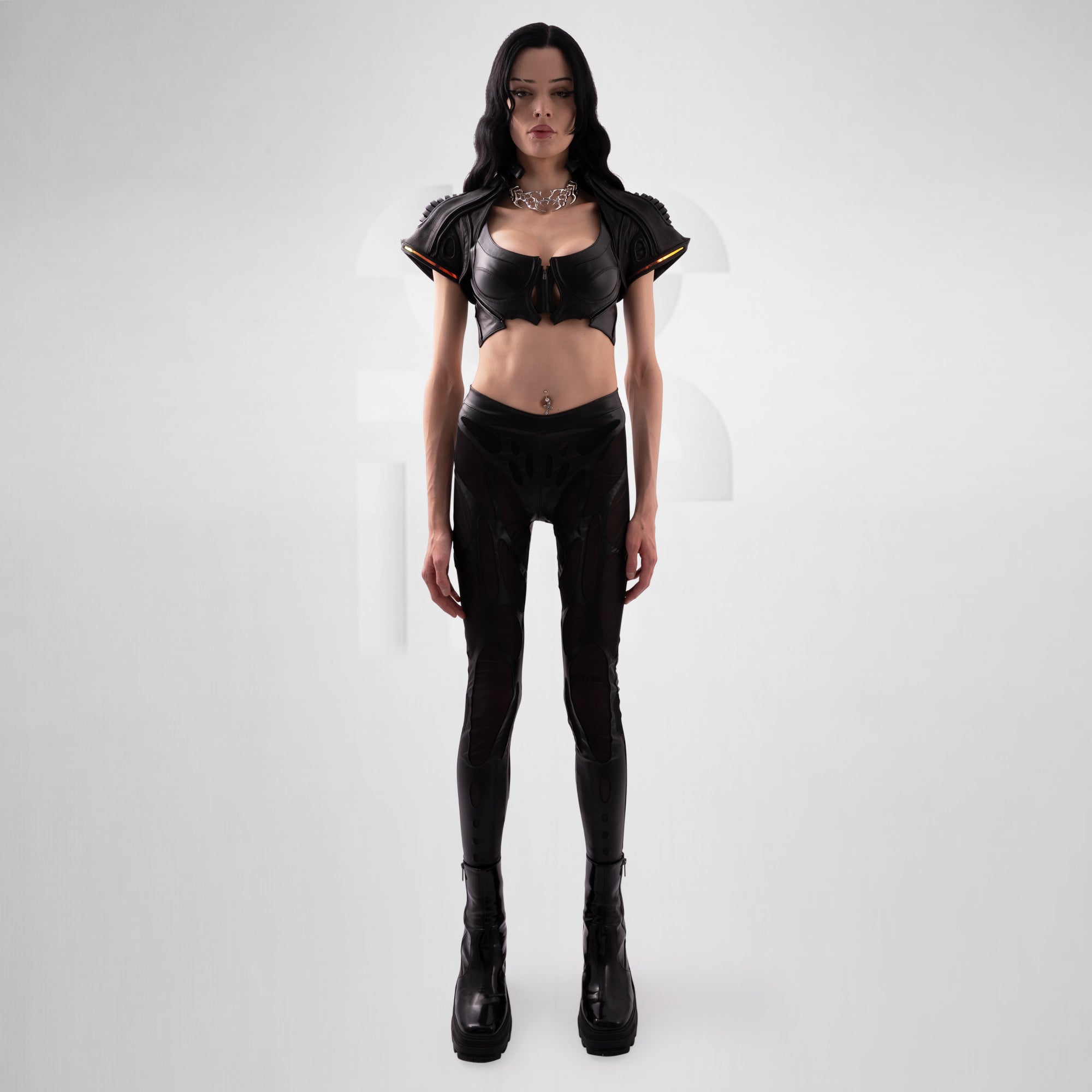 Person wearing a black outfit with a top and pants on a white background