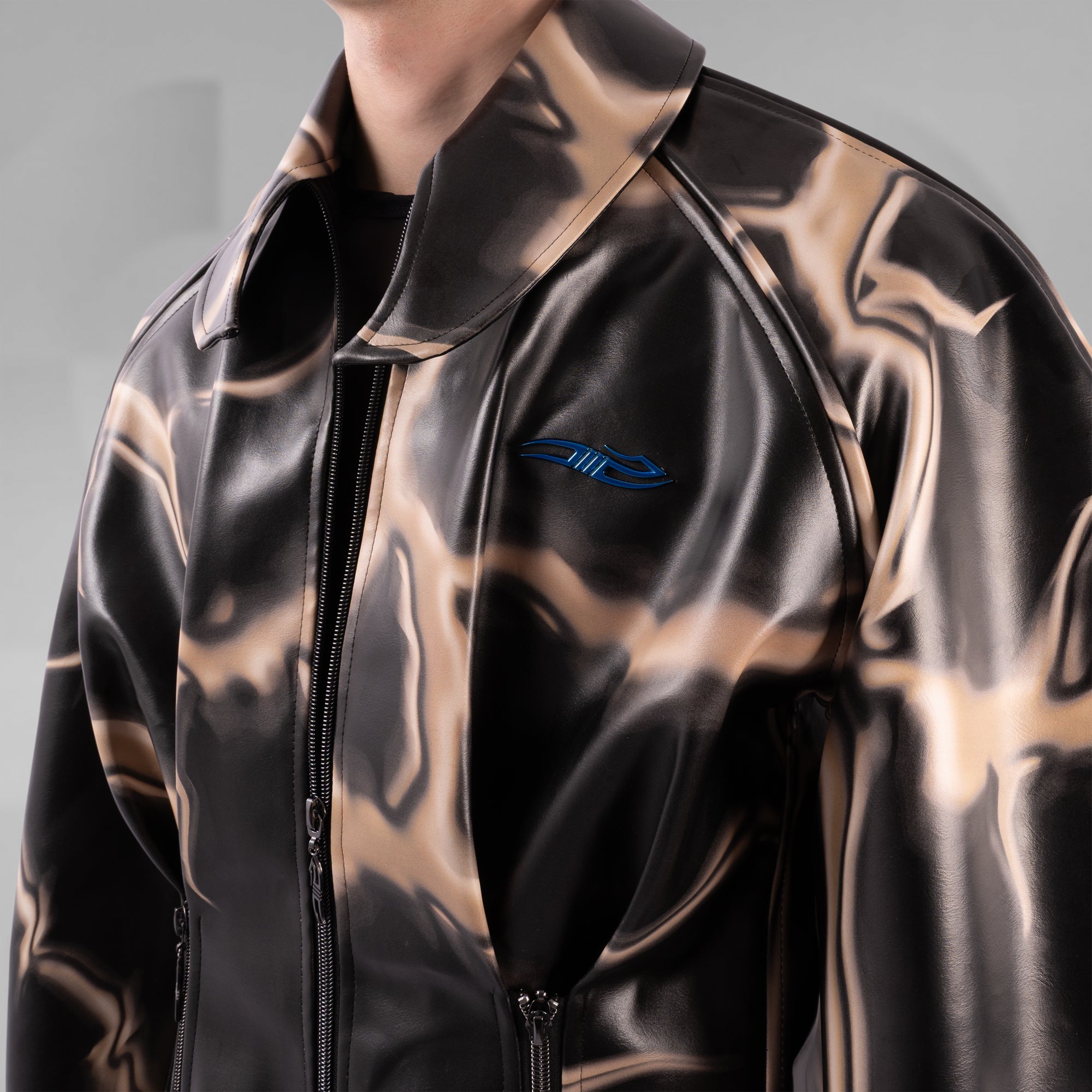 Black and gold reflective jacket with a blue logo on a gray background