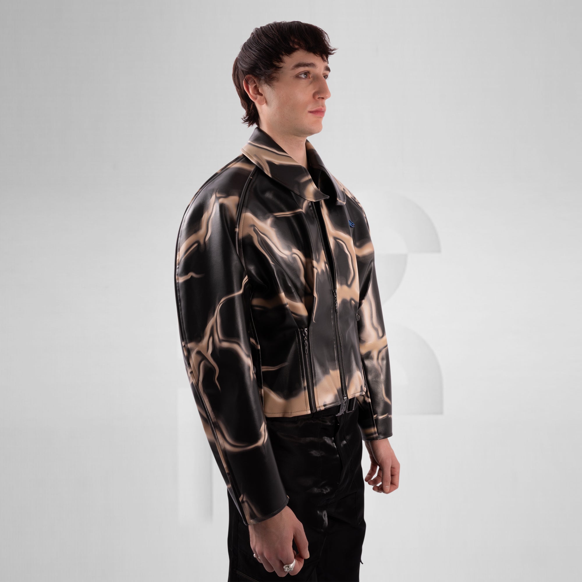 Man wearing a patterned jacket on a plain background