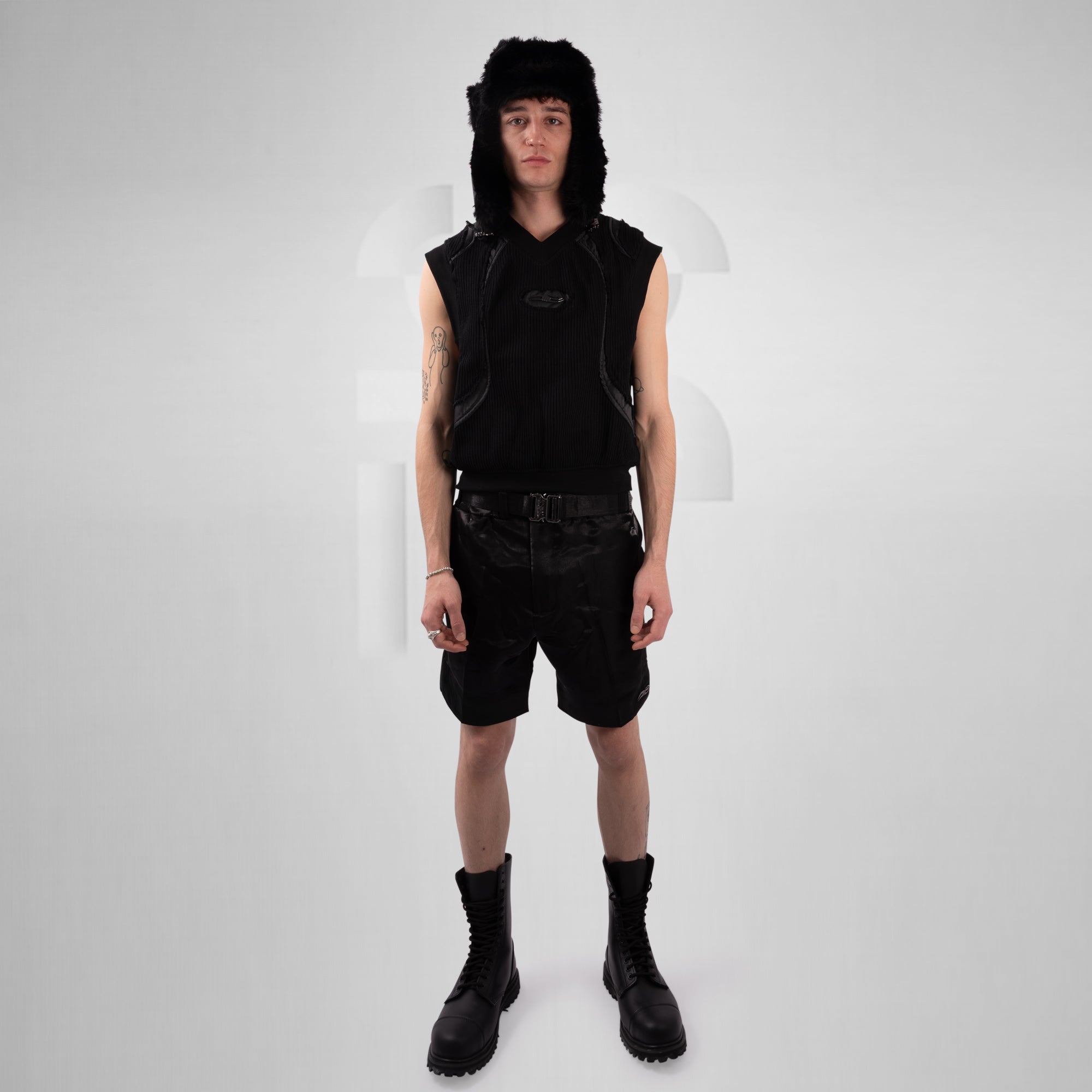 Person wearing a black outfit with a hat on a white background