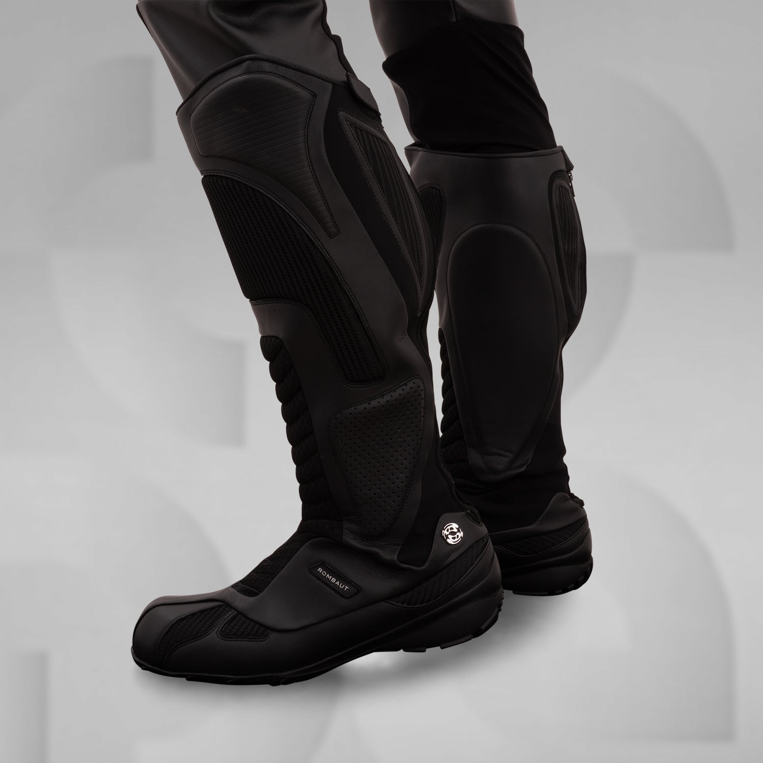 The image features sleek, futuristic black boots with a high, protective design. These avant-garde boots boast textured panels and reinforced sections, combining style and functionality. Ideal for fashion-forward individuals, they offer both comfort and edgy aesthetics, making them perfect for urban adventures or making a statement in any environment.