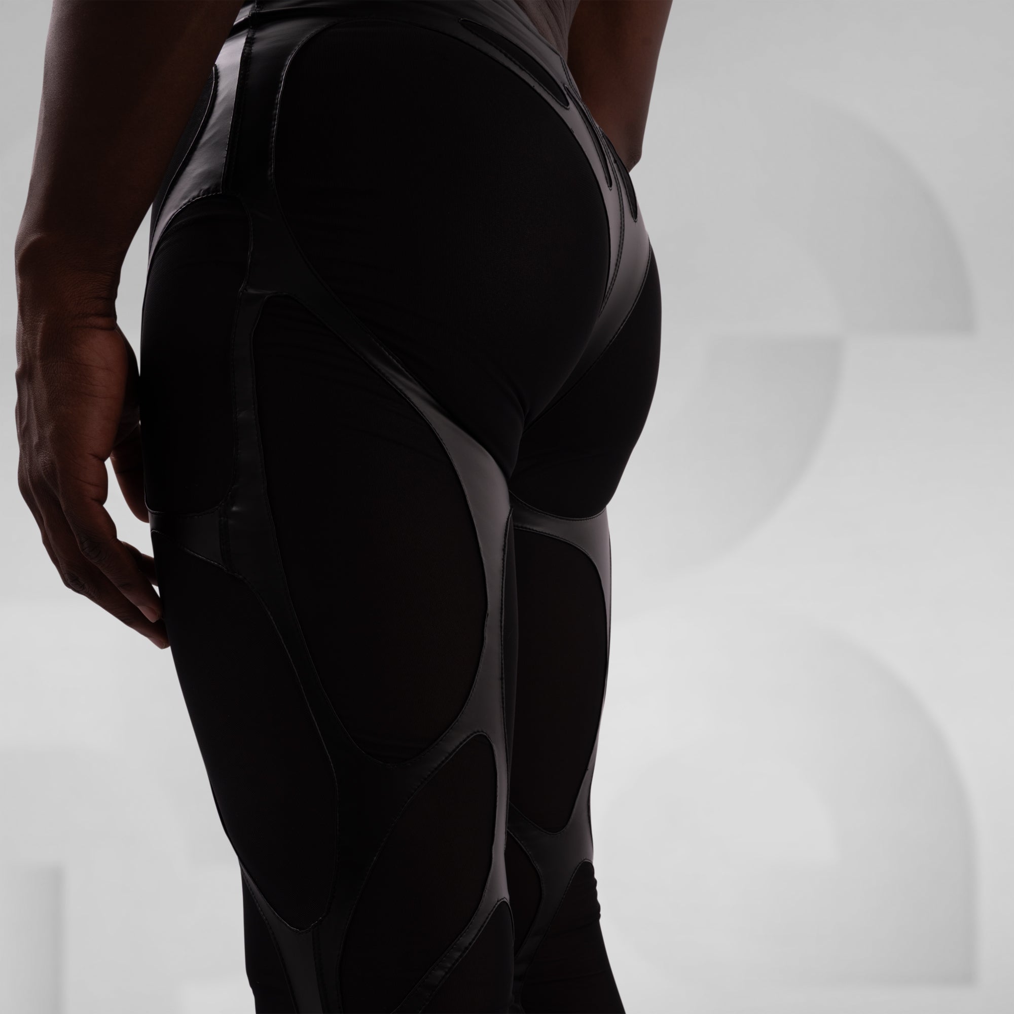 Person wearing black compression leggings on a light gray background