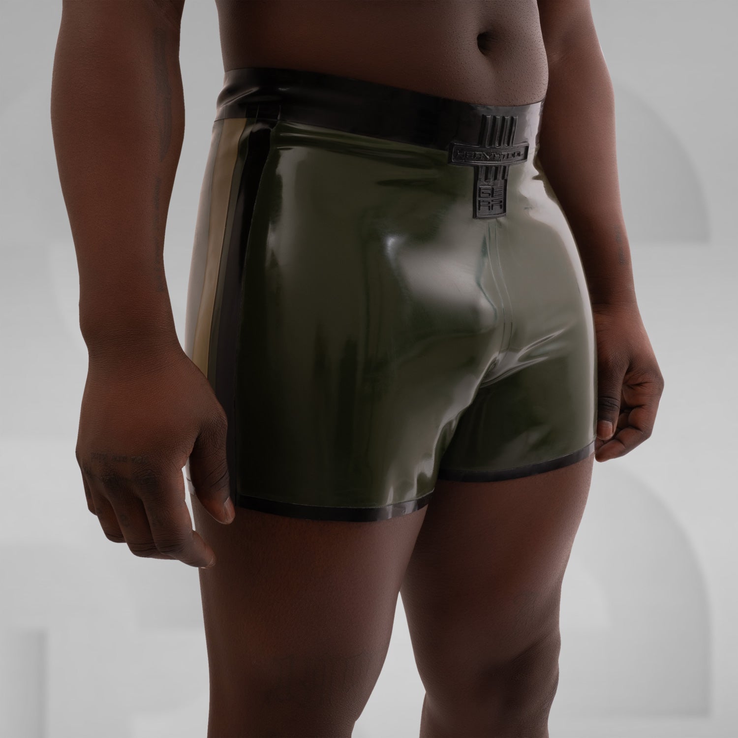 A pair of dark green latex pants featuring a 3D Latex brand ornament on the side.