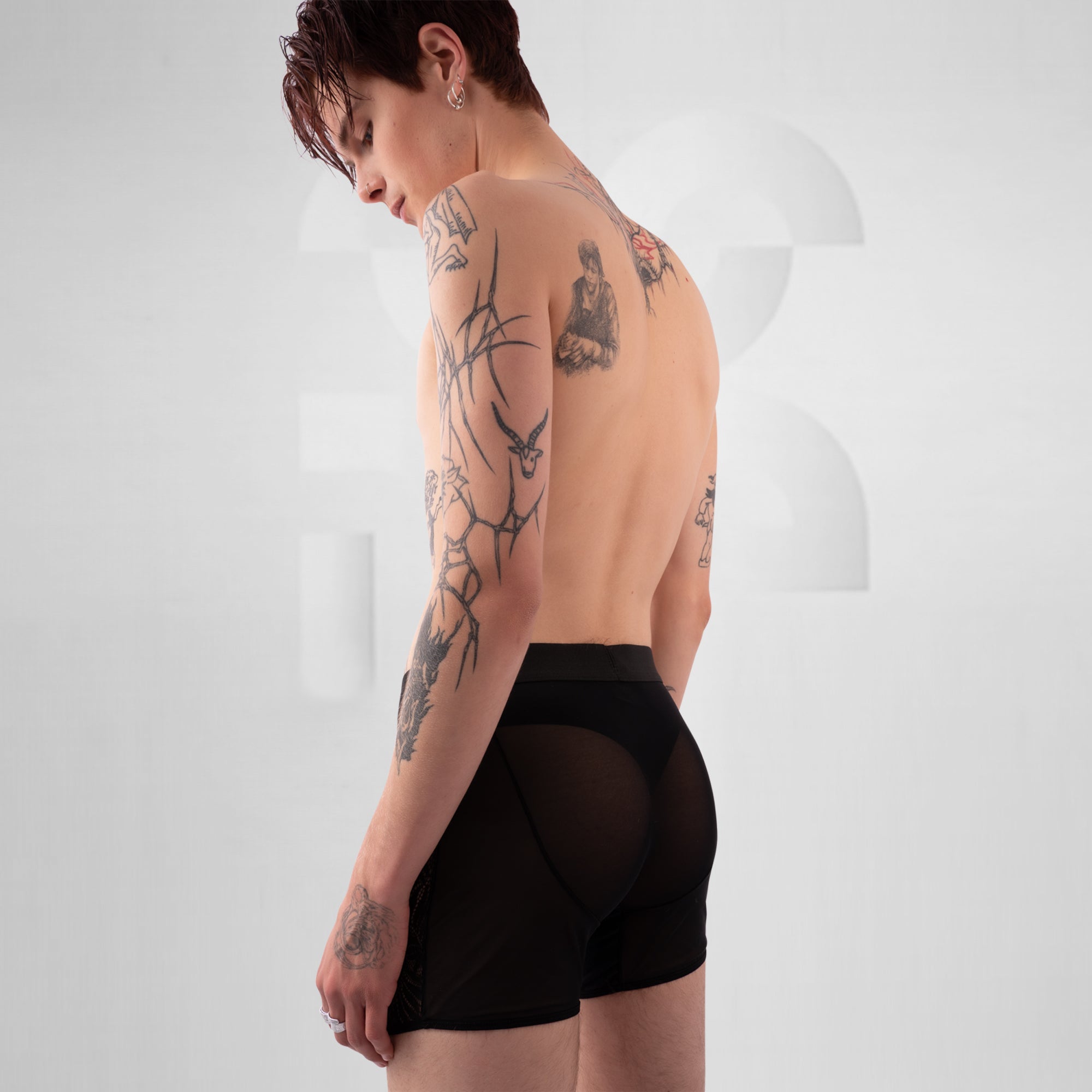 Person wearing black high-waisted underwear with a plain background