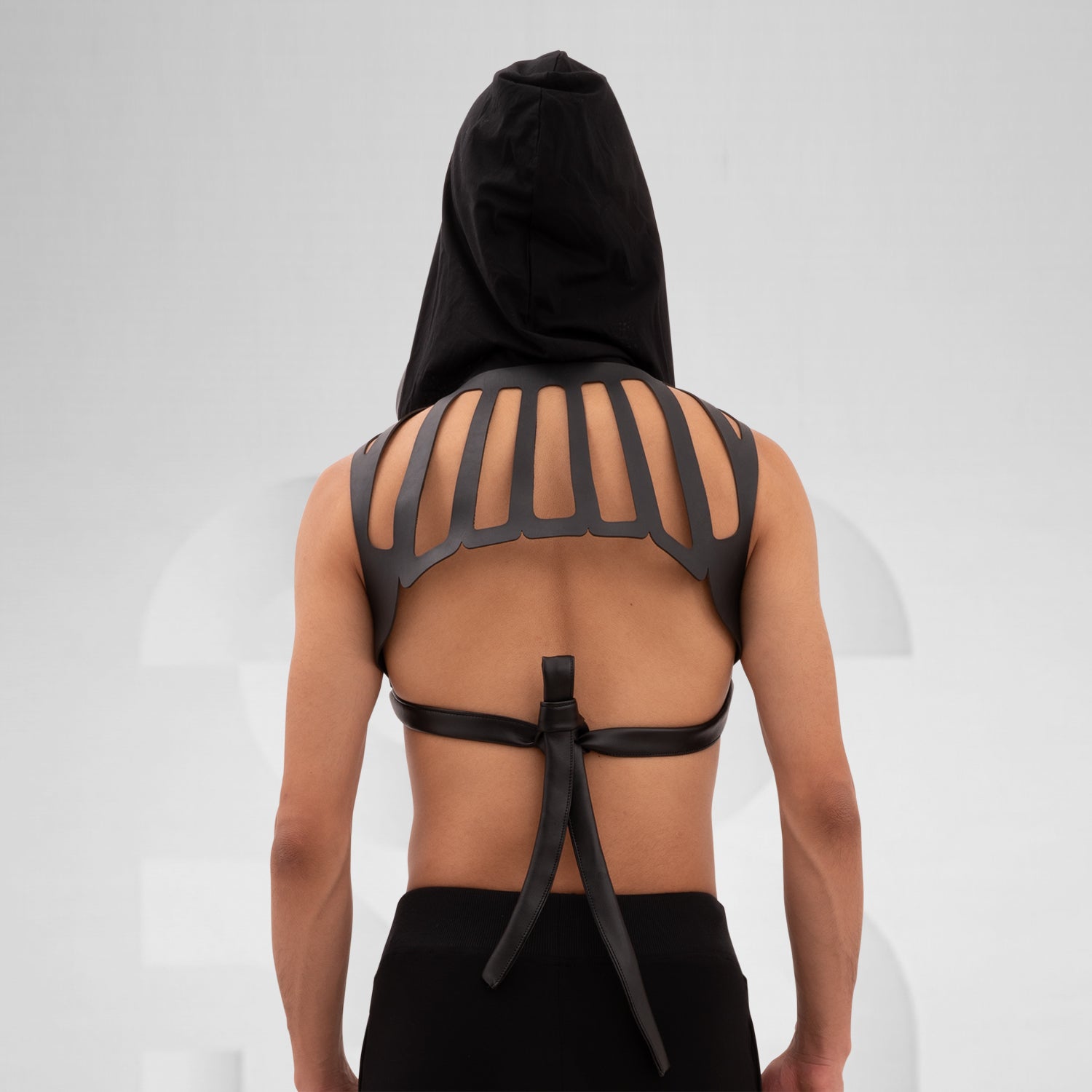 The Laser Cut Harness with Hood from Cyberesque is a striking fusion of avant-garde design and innovative clubwear. Featuring eye-catching laser-cut details on the back, this harness delivers a bold visual impact that is sure to make a statement. The adjustable straps ensure a perfect fit, allowing for both comfort and style as you navigate the nightlife scene. Paired with sleek trousers, this ensemble exudes modernity and confidence, making it ideal for fashion-forward individuals who are unafraid to embra
