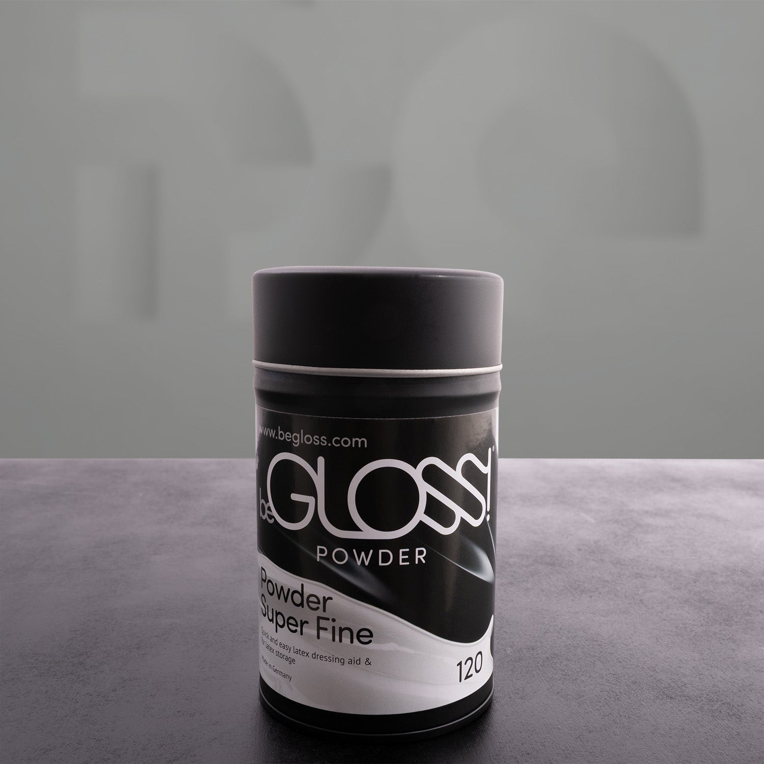 black latex poweder box in front of grey background