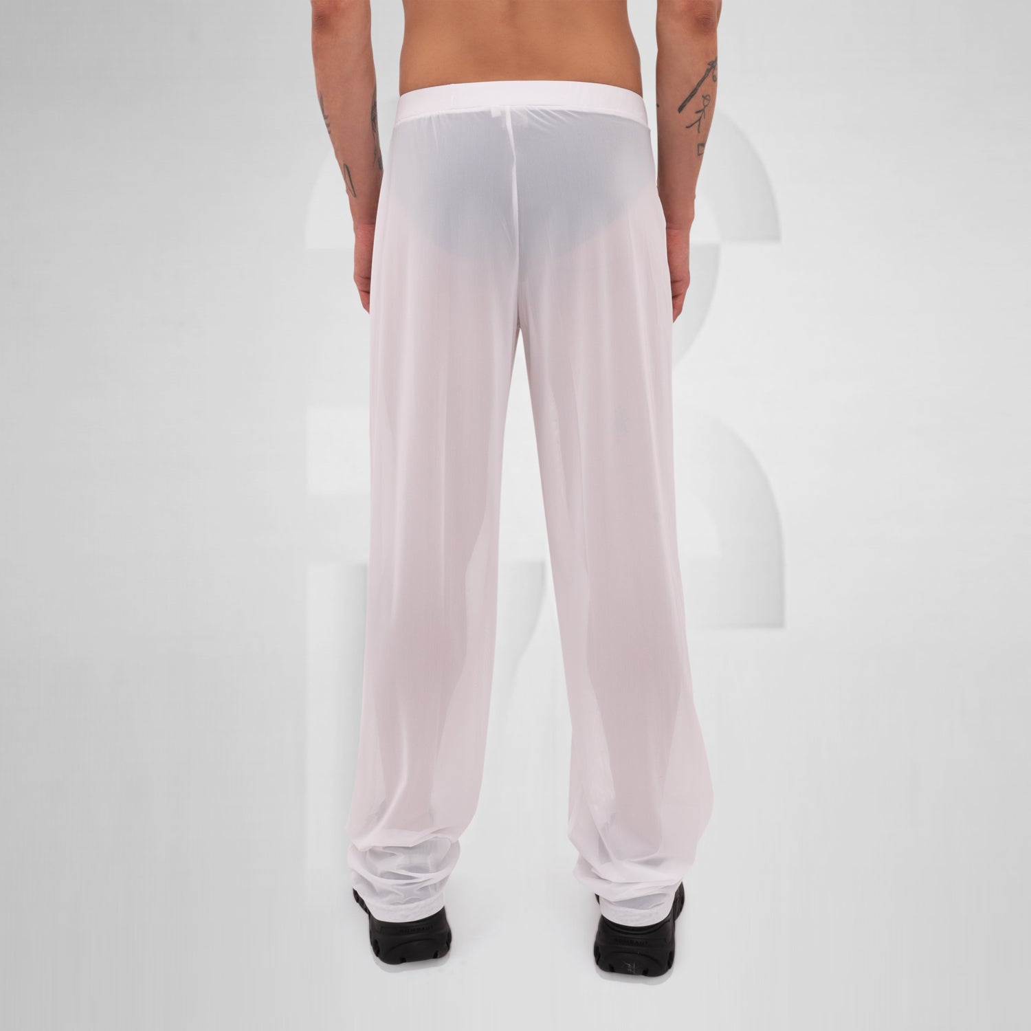 Gender-neutral white mesh pants with a relaxed fit, designed for the Berlin club scene and modern clubwear fashion