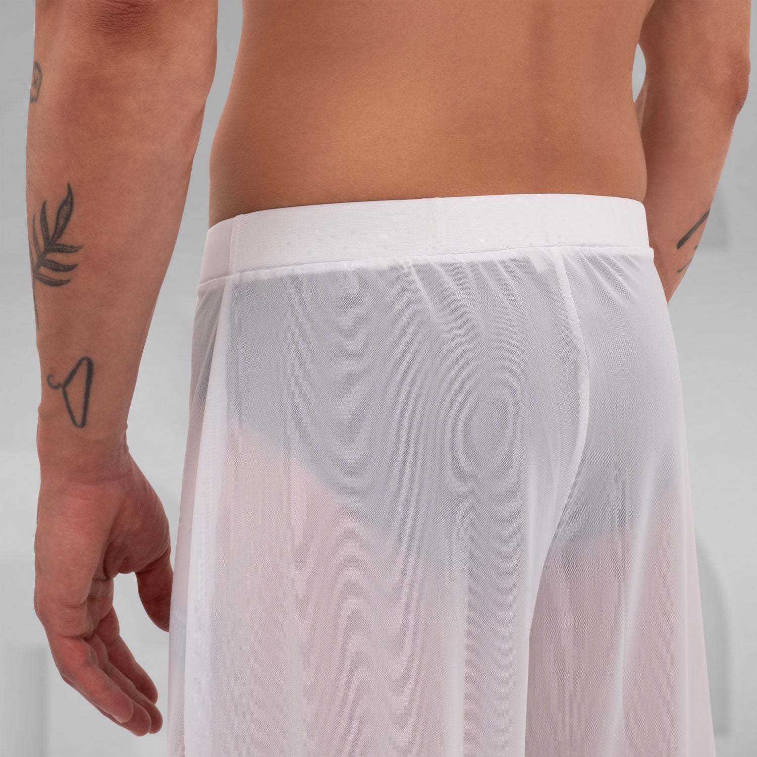 Gender-neutral white mesh pants with a relaxed fit, designed for the Berlin club scene and modern clubwear fashion