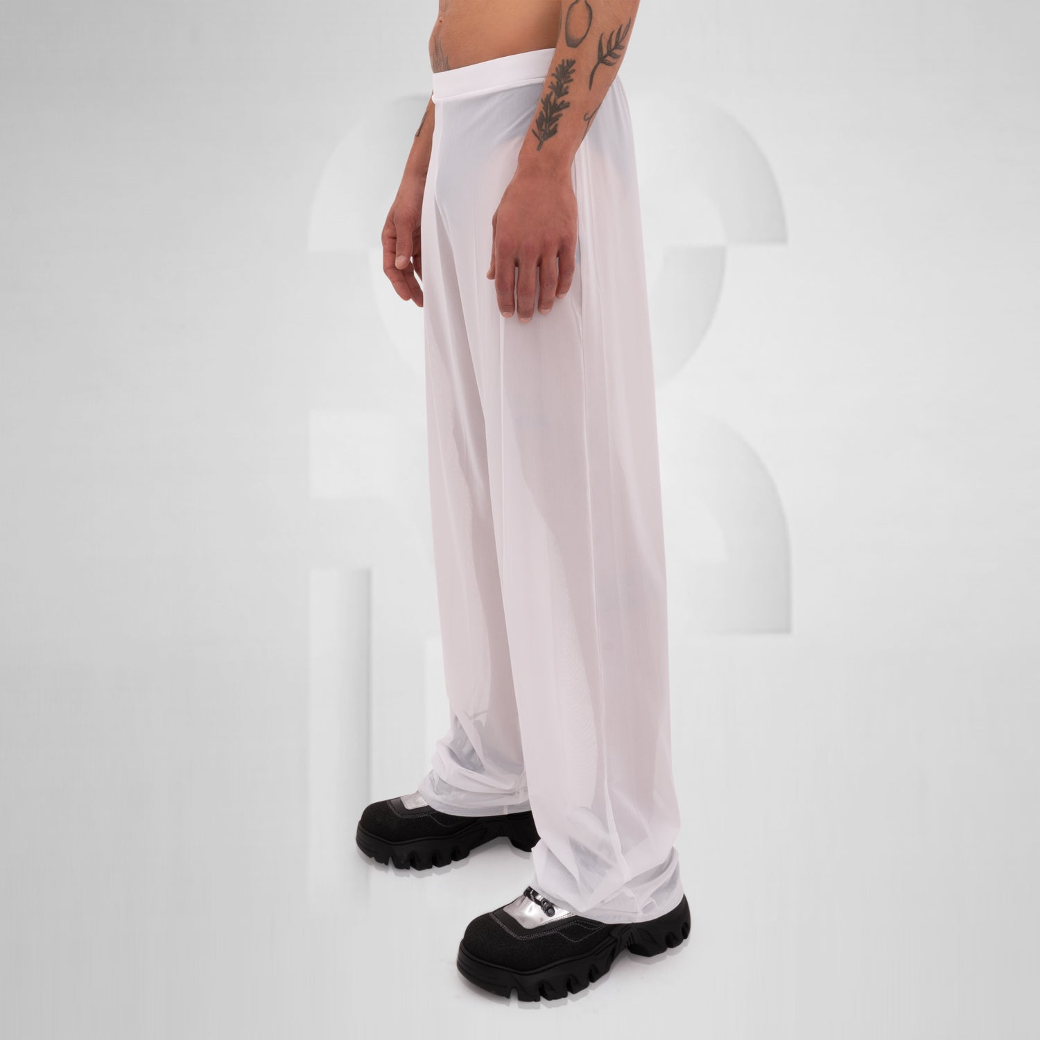 Gender-neutral white mesh pants with a relaxed fit, designed for the Berlin club scene and modern clubwear fashion