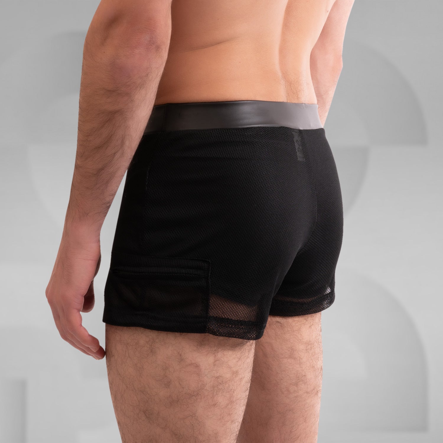 The image showcases a pair of striking black shorts that blend edgy design with functionality. Crafted from sleek, high-quality material, these shorts feature mesh side panels for enhanced breathability and a modern look. With a tailored fit that highlights the physique, they are perfect for both clubwear and casual outings, making a bold statement for anyone looking to embrace their unique style. Ideal for dancing the night away or making an impression in any setting!