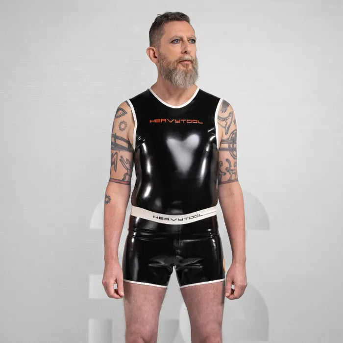 The image features sleek black shorts from HeavyTool Gear, designed for a bold and eye-catching look. The shiny latex material hugs the body, creating a striking silhouette, while the contrasting waistband adds a stylish touch. Perfect for both clubwear and performance, these shorts exude confidence and a unique sense of style.
