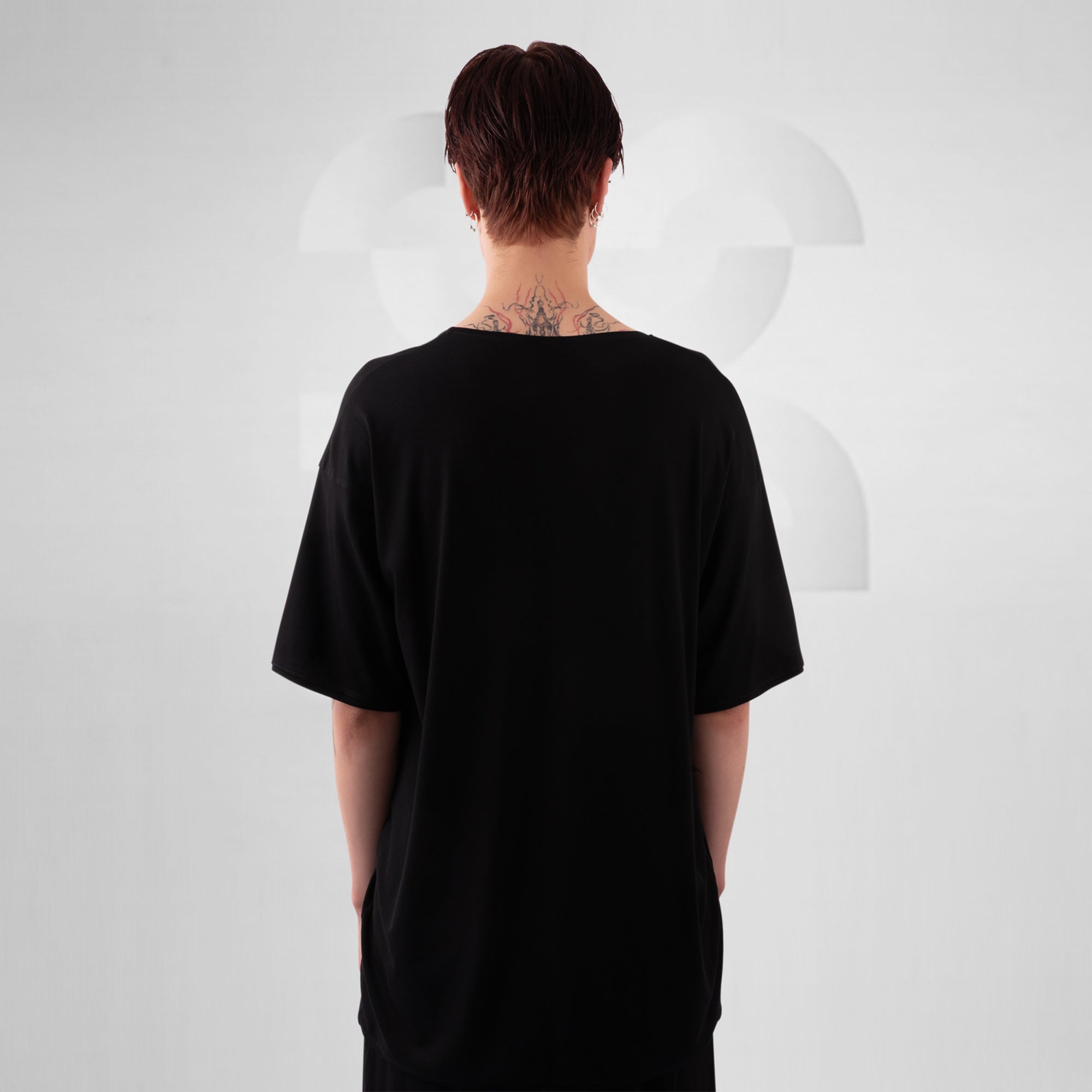 Person wearing a black t-shirt with a plain white background