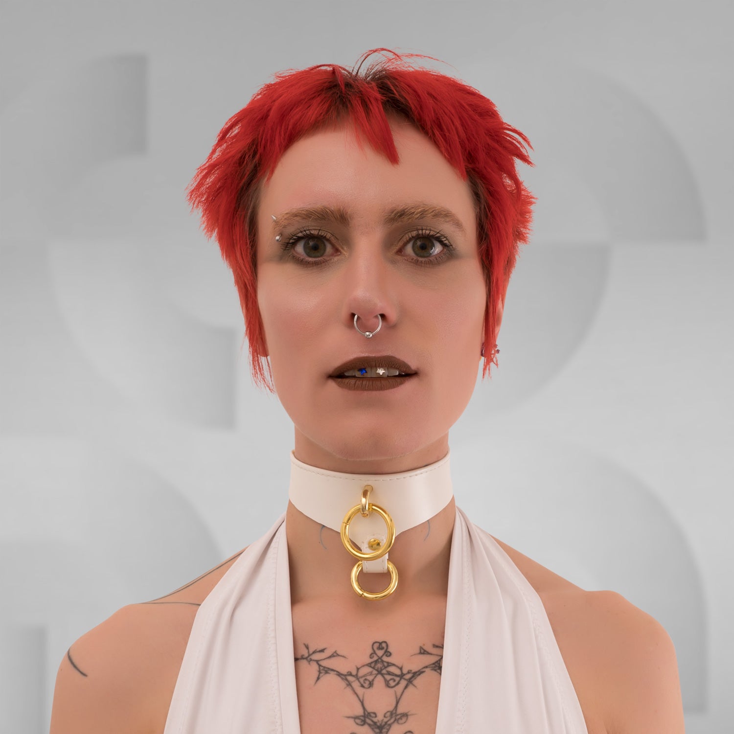 This image features a model showcasing a sleek white PU double choker with striking gold rings at the center front. The choker elegantly frames her neck, adding a bold yet refined touch to her look. Its minimalist design accentuates her features while embodying a modern aesthetic that effortlessly blends sophistication with an edgy vibe.