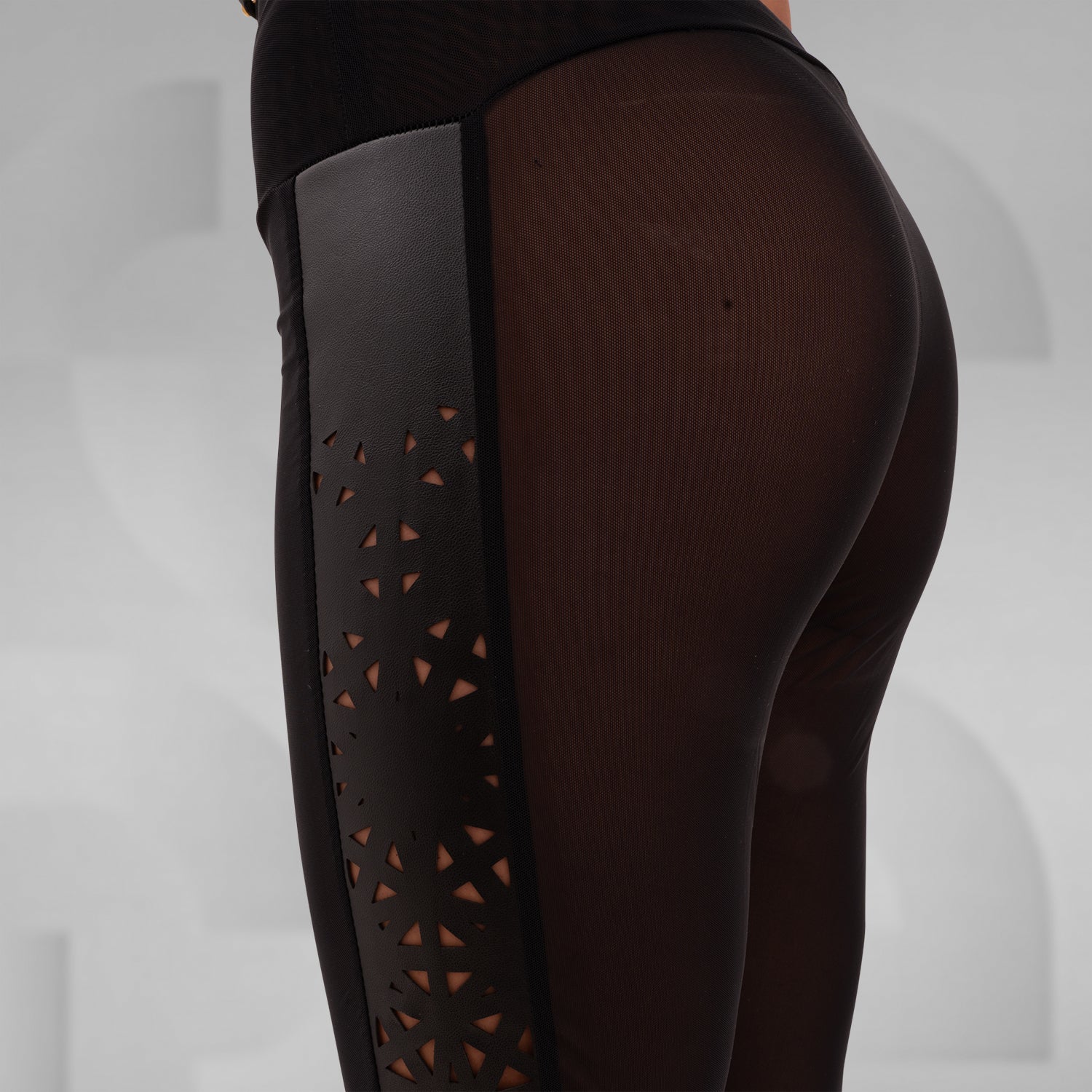 Sheer mesh leggings featuring a faux leather laser-cut panel with a psychedelic pattern, designed for bold self-expression and perfect for festivals, nightlife, and avant-garde outfits.