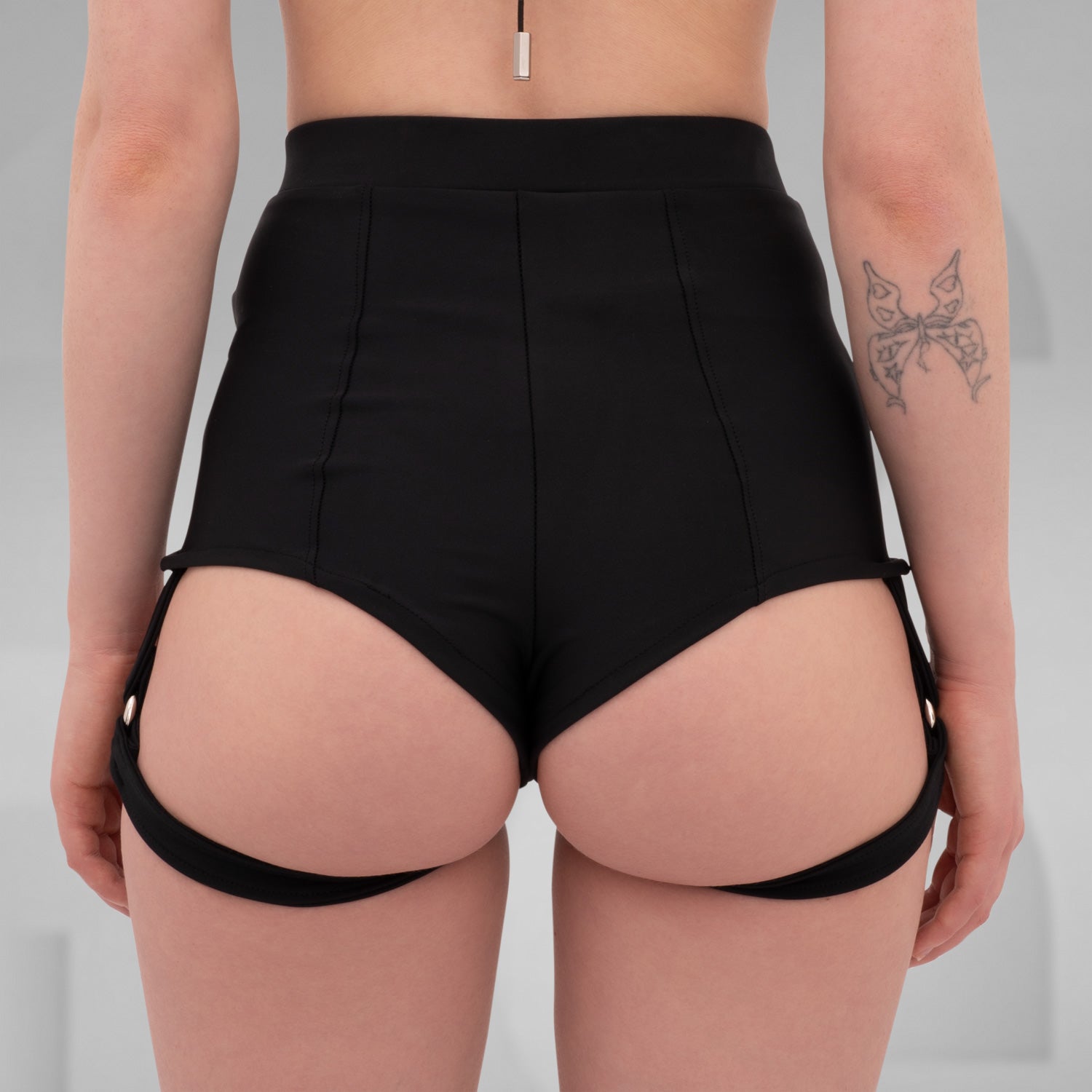 Side view of high-waisted black shorts with attached garter straps, designed for the Berlin club scene and edgy nightlife fashion.