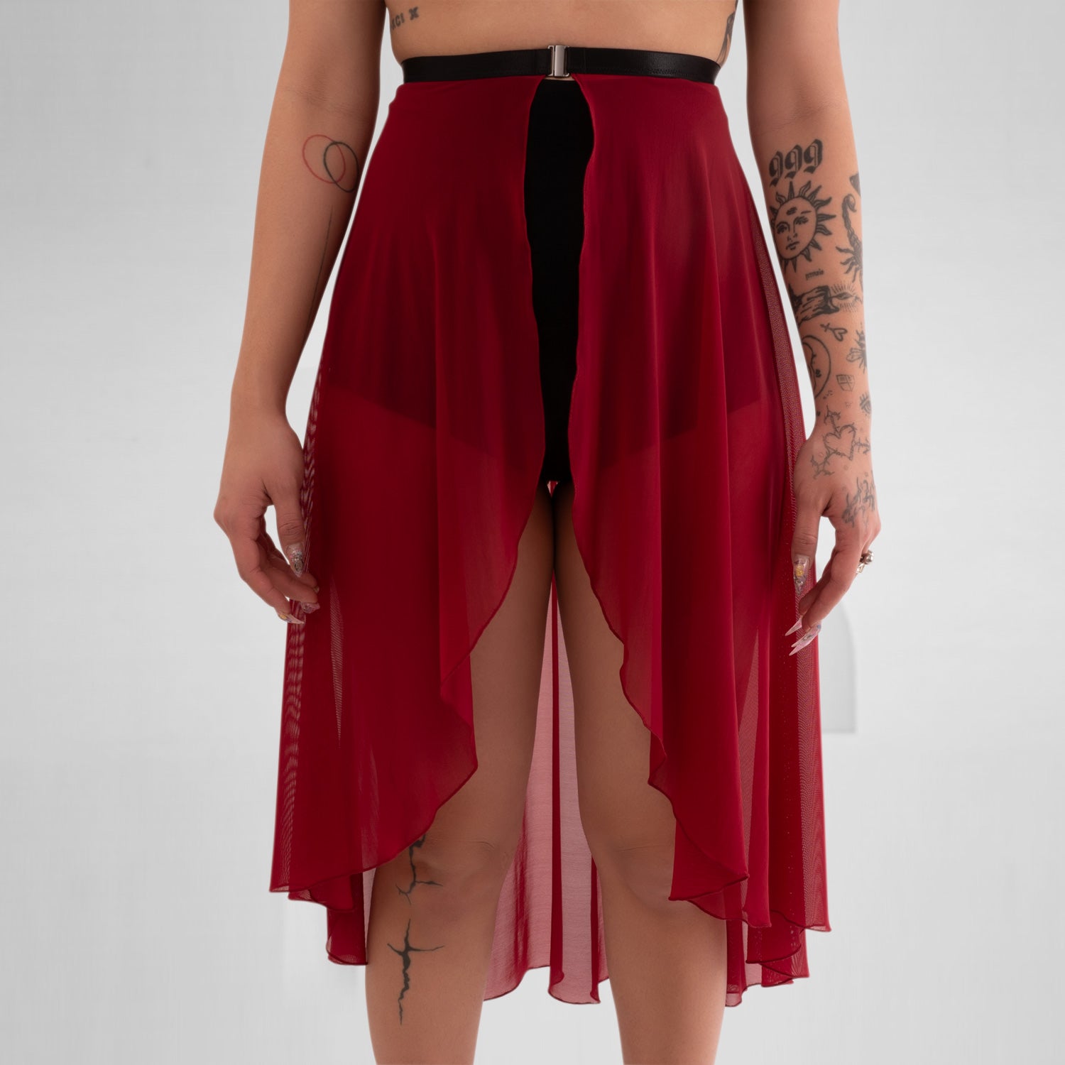 Front Split of a sheer, flowing asymmetric Mesh Skirt in Red, equipping you for ruling the night in edgy elegance.