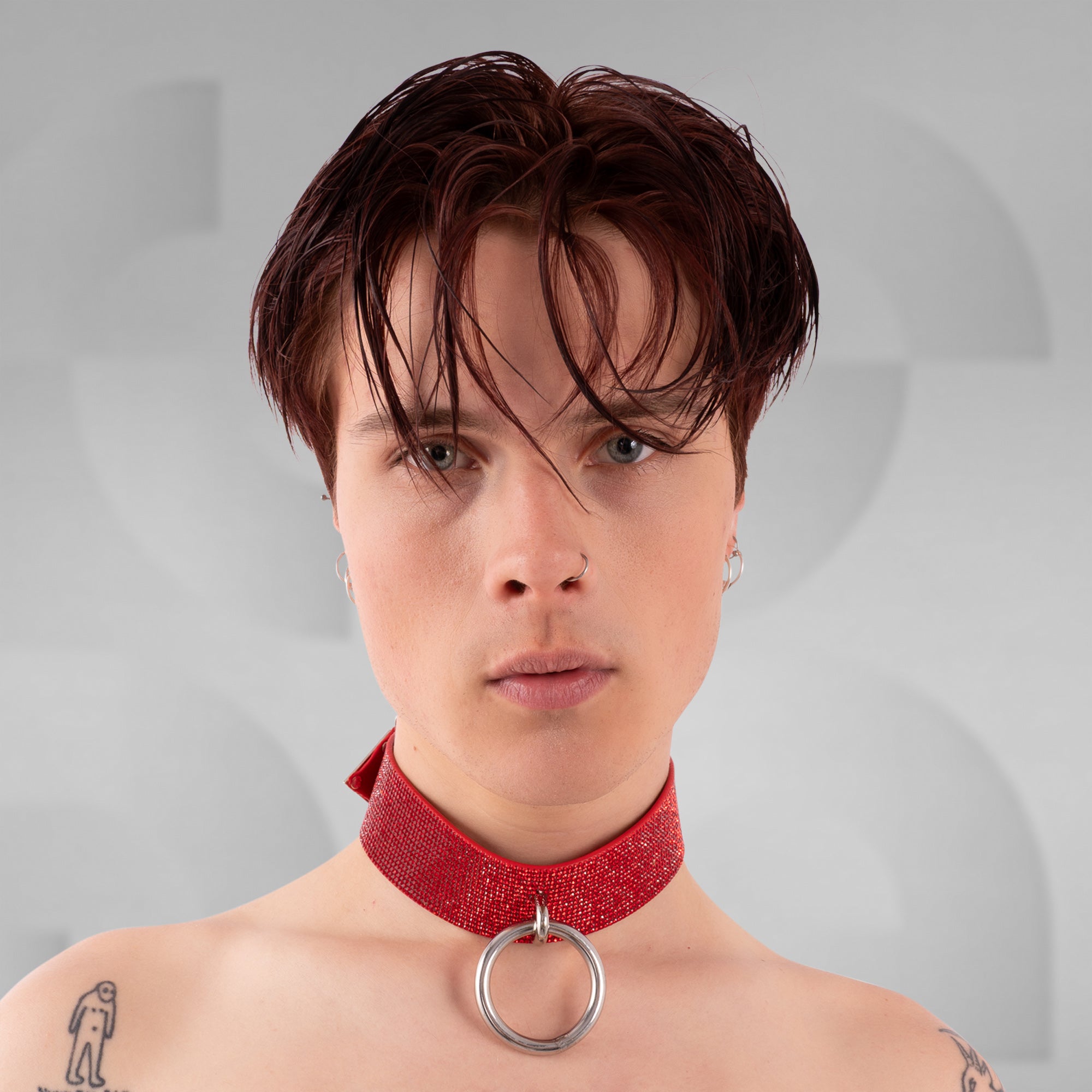 Person wearing a red choker with a gray background