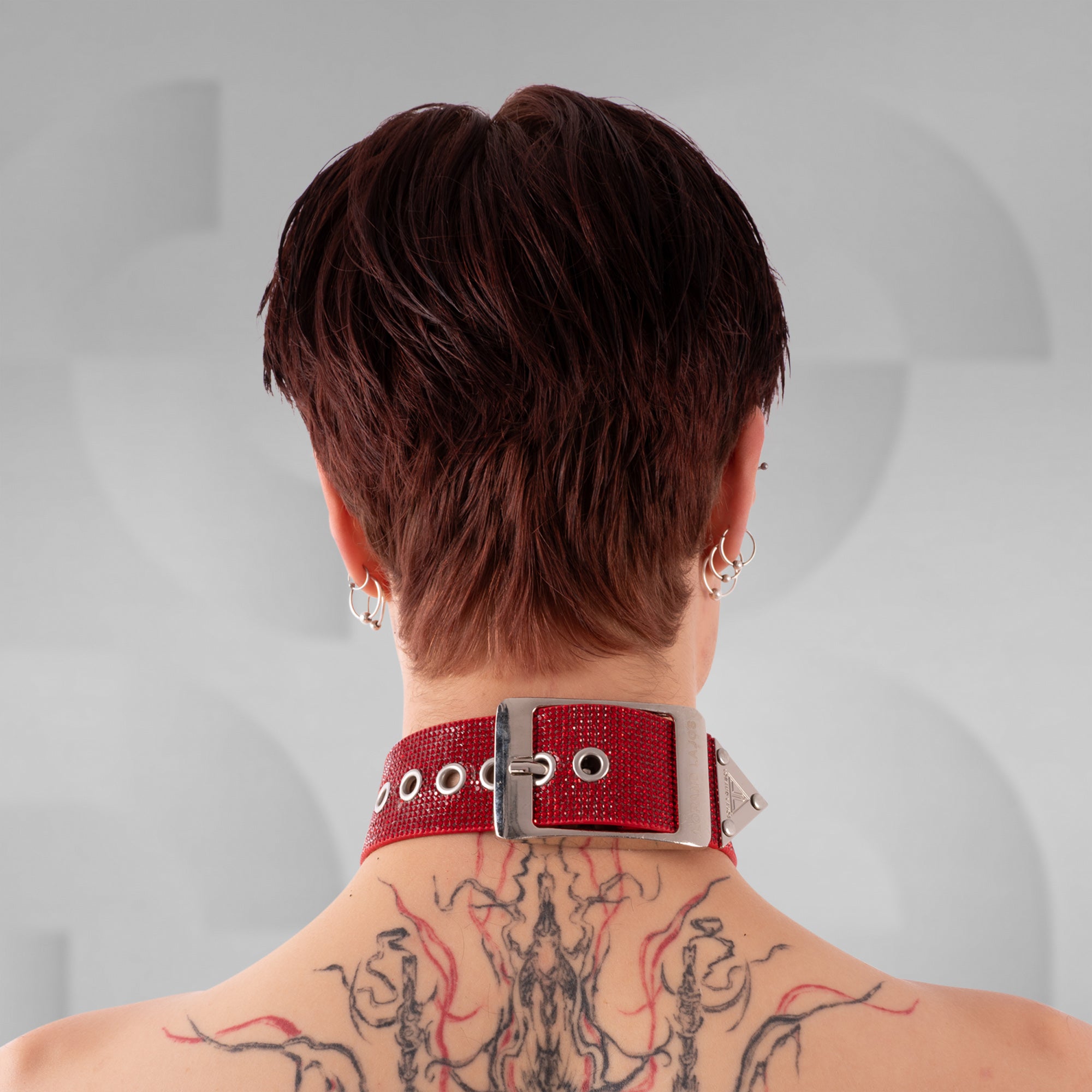 Person wearing a red choker with a blurred background