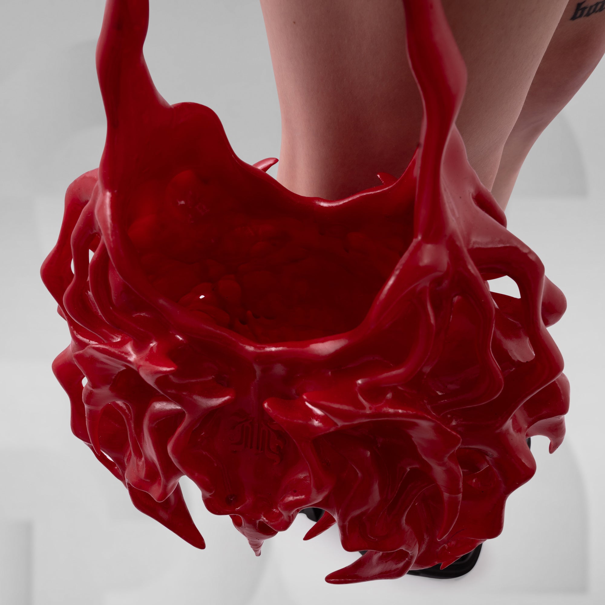 Red liquid splashing out of a container on a white background