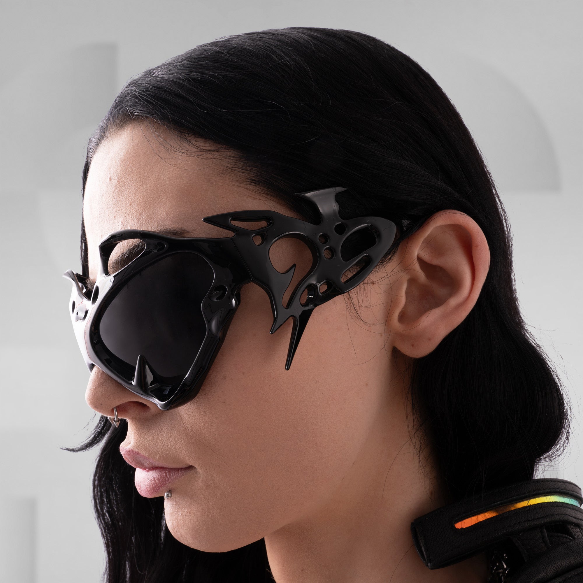 Person wearing futuristic black goggles with a plain background