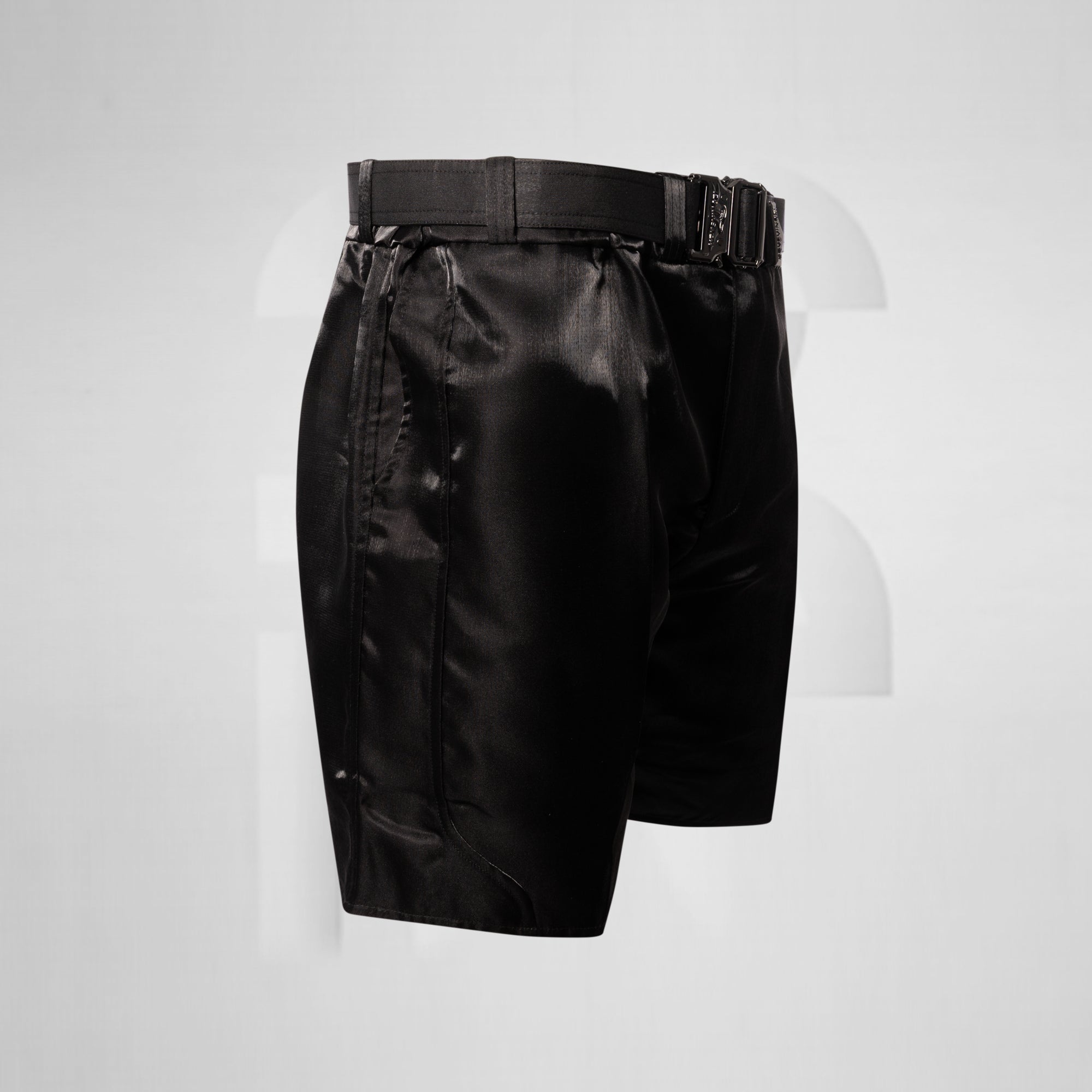 Black satin shorts with a belt on a light gray background