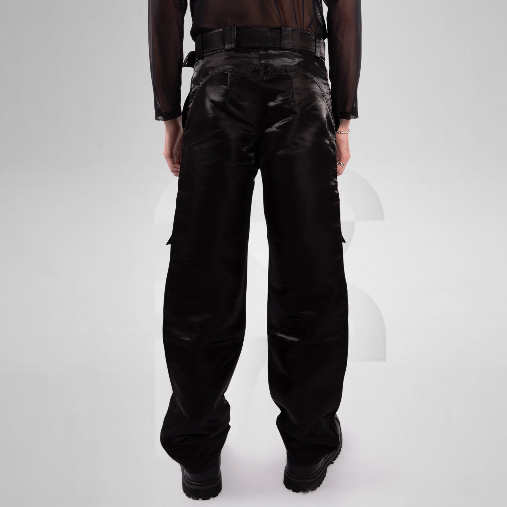 Person wearing black leather pants on a white background