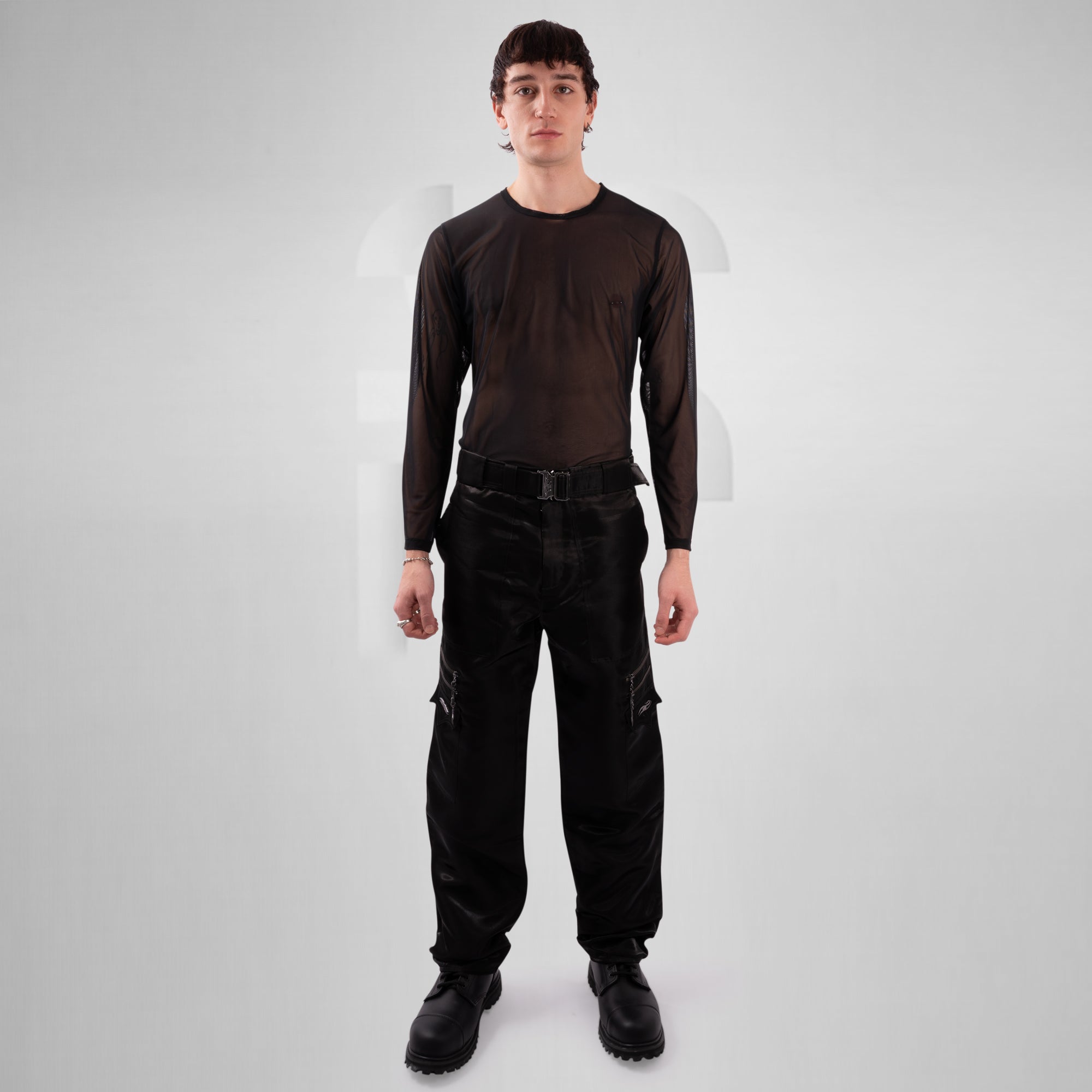 Person wearing a black long-sleeve shirt and black pants on a white background