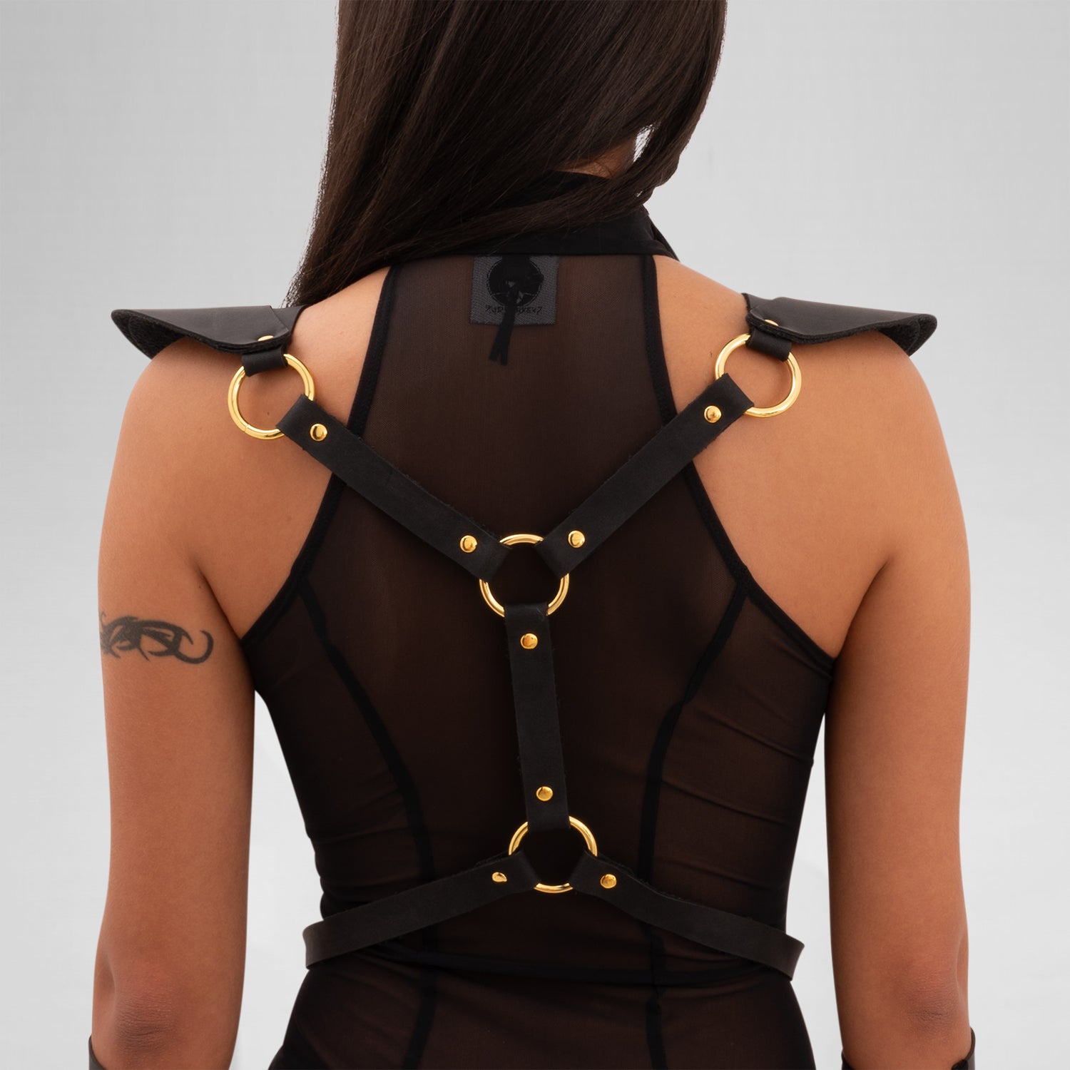 The Laser Cut Harness with Shoulder Details from designer Cyberesque is a daring fusion of avant-garde fashion and functionality. This eye-catching harness features intricate laser-cut designs that draw attention and elevate your outfit to new heights. With striking gold hardware and chic shoulder accents, it’s perfect for festivals, clubwear, and tribal gatherings. Designed for those who embrace their individuality and confidence, this piece transforms any ensemble into a bold statement that captures the e