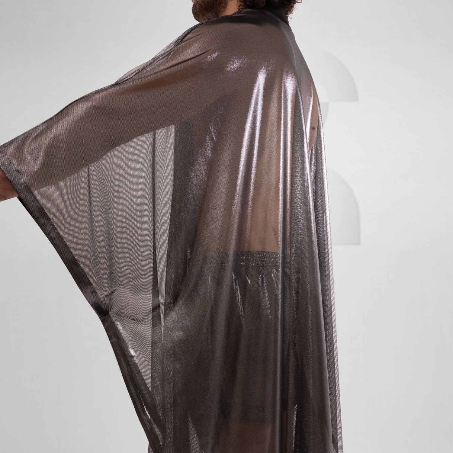 A striking long poncho in red, blue, and silver with a shiny disco festival vibe.