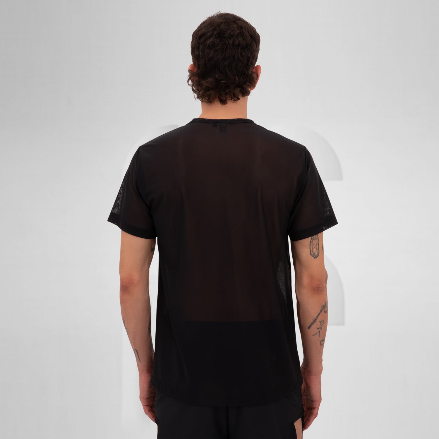 Model showcasing a black mesh short sleeve top, perfect for Berlin nightlife.