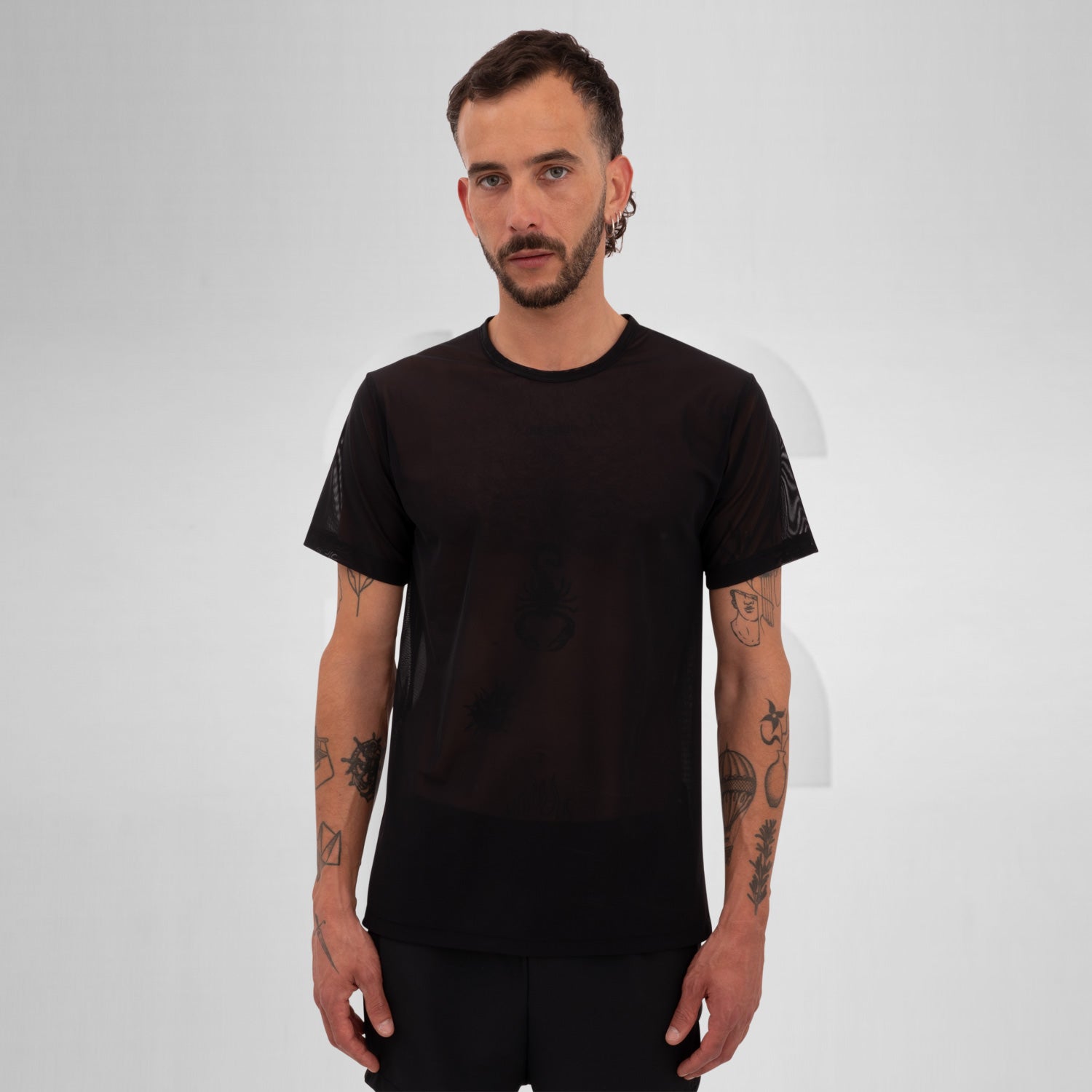 Model showcasing a black mesh short sleeve top, perfect for Berlin nightlife.