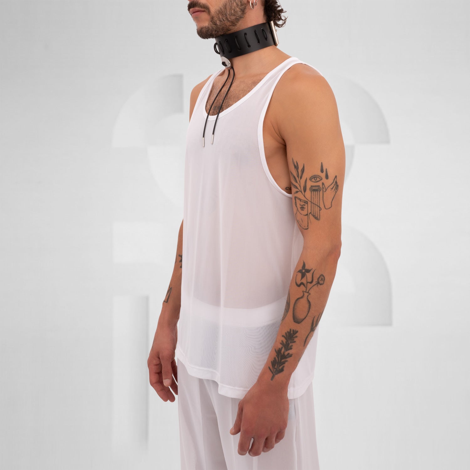 Model wearing a white mesh tank top, embodying Berlin club fashion.