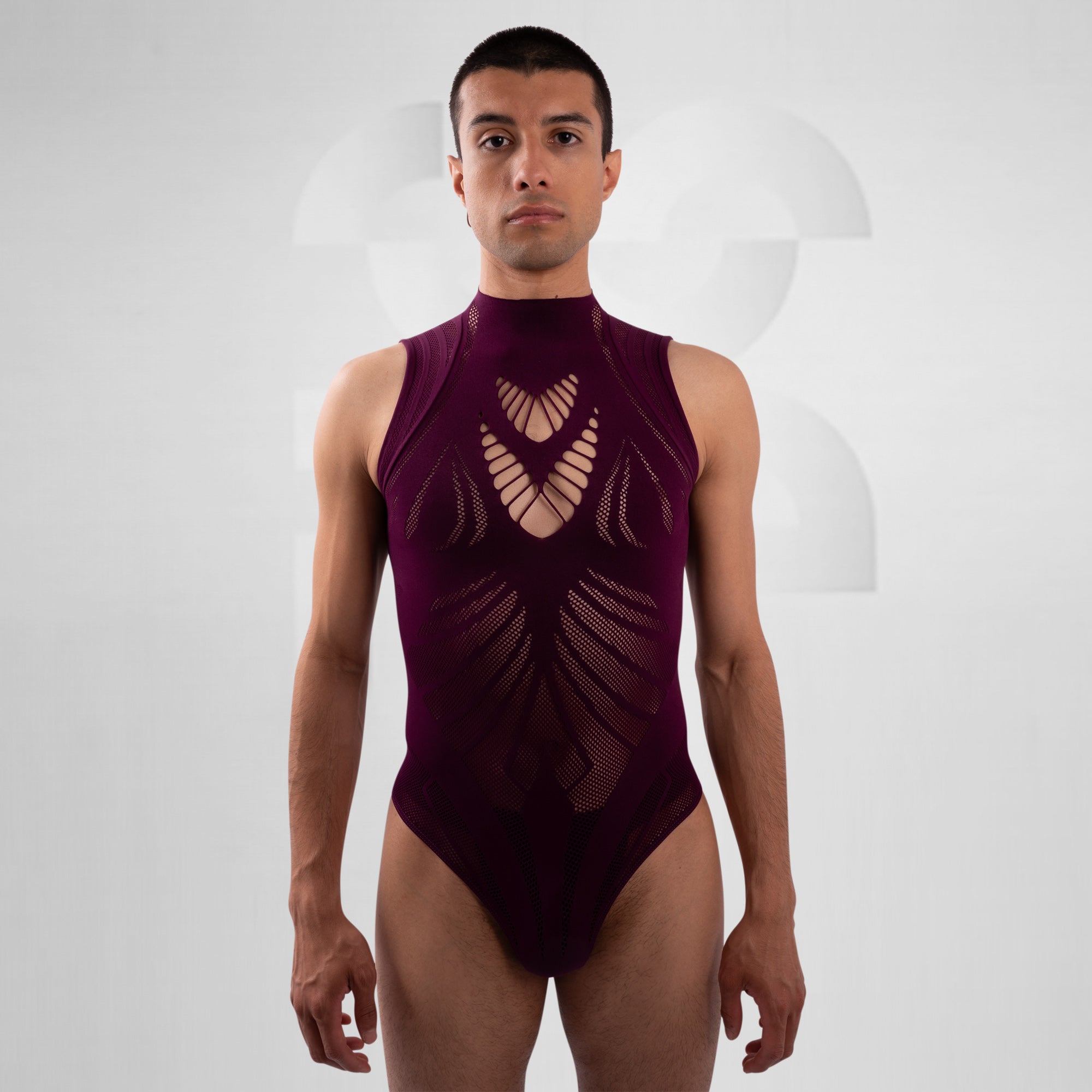 Man wearing a maroon swimsuit with cut-out design on a white background